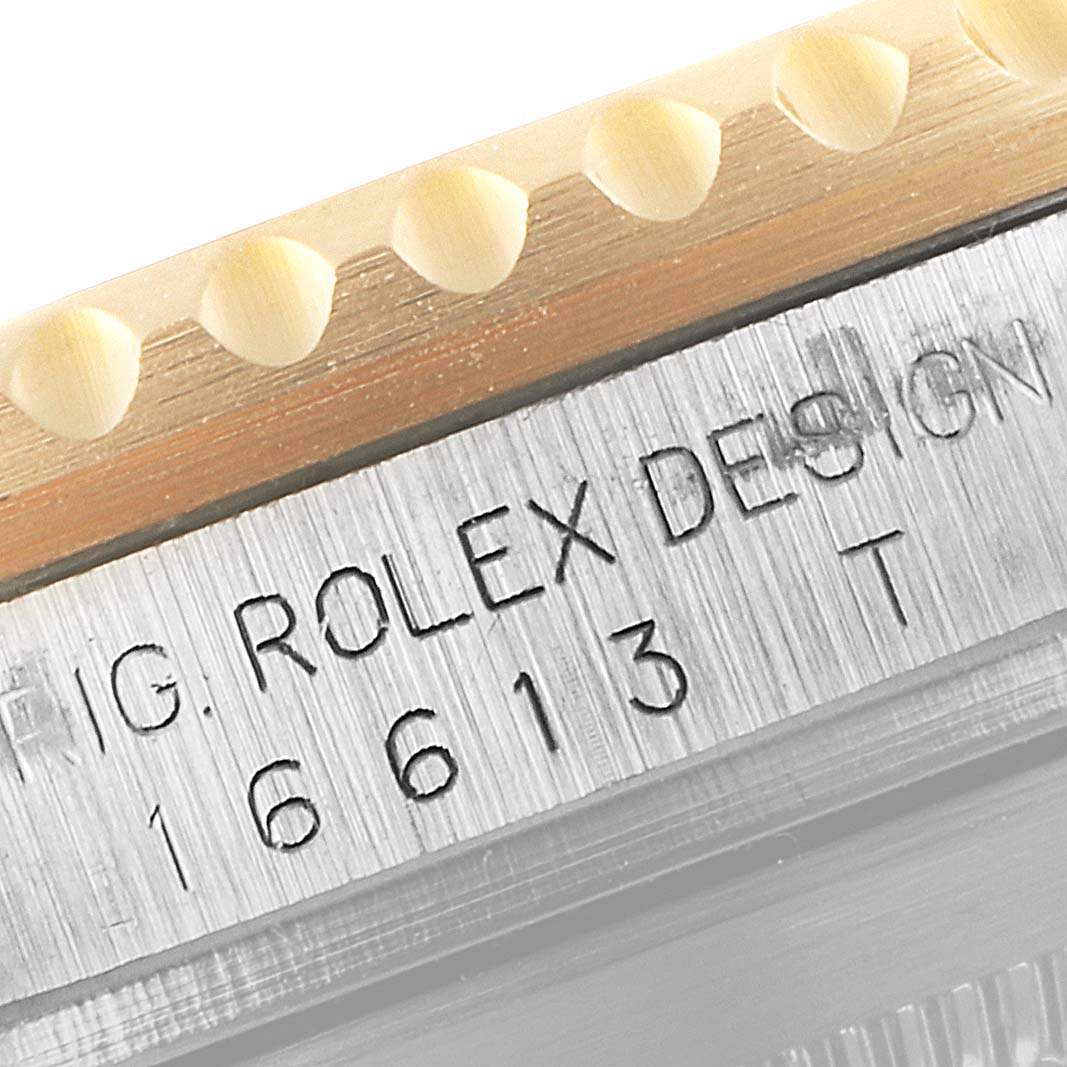 This close-up image shows the side of a Rolex Submariner 16613 Men's Steel and Gold (two tone) Champagne Dial 16613 Men's Steel and Gold (two tone) Champagne Dial watch, focusing on the engraved model number "16613T" and part of the bezel.