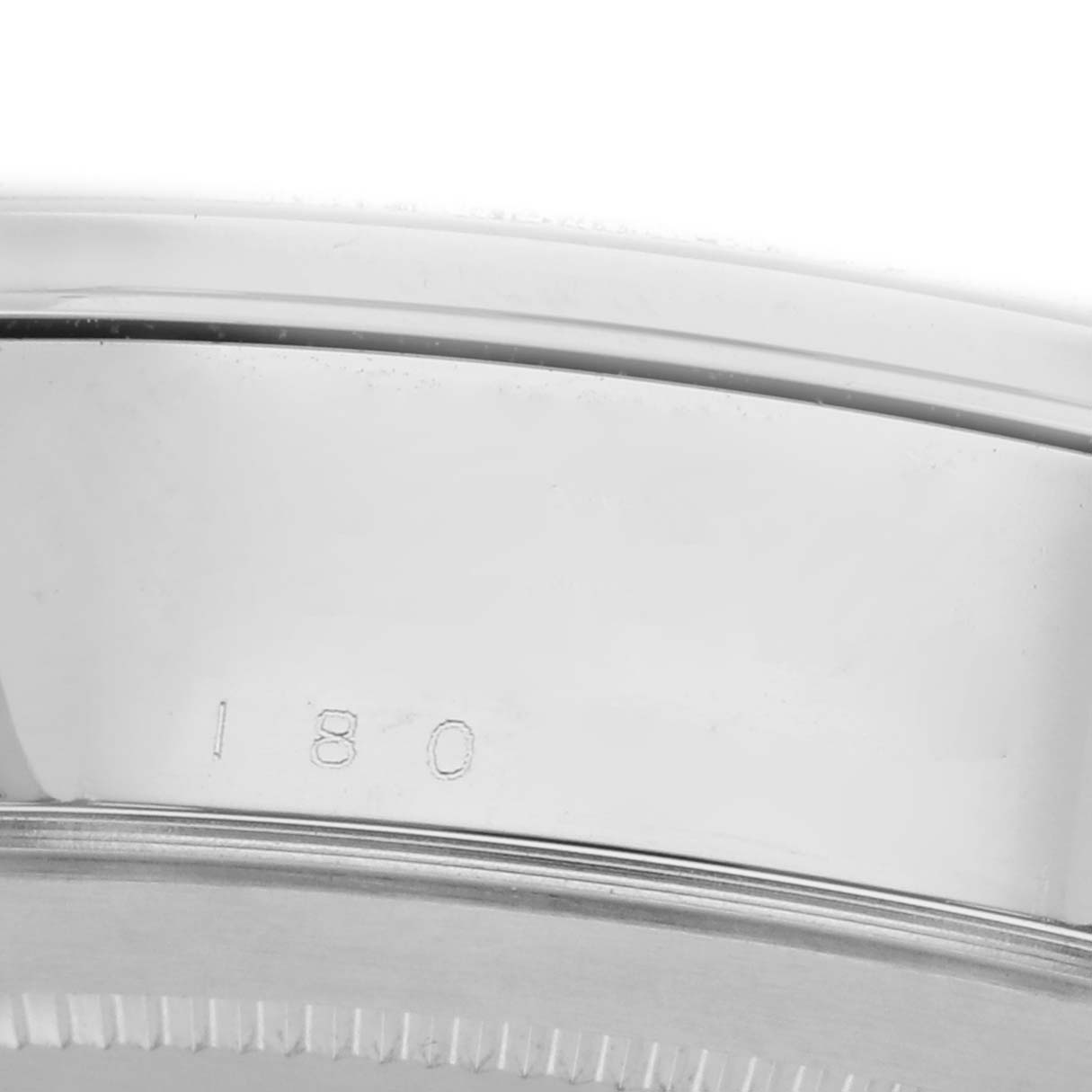 The image shows a close-up of the bezel and edge of the case for a Tudor Glamour 56000 Men's Stainless Steel Black Dial model, featuring a partial serial number.