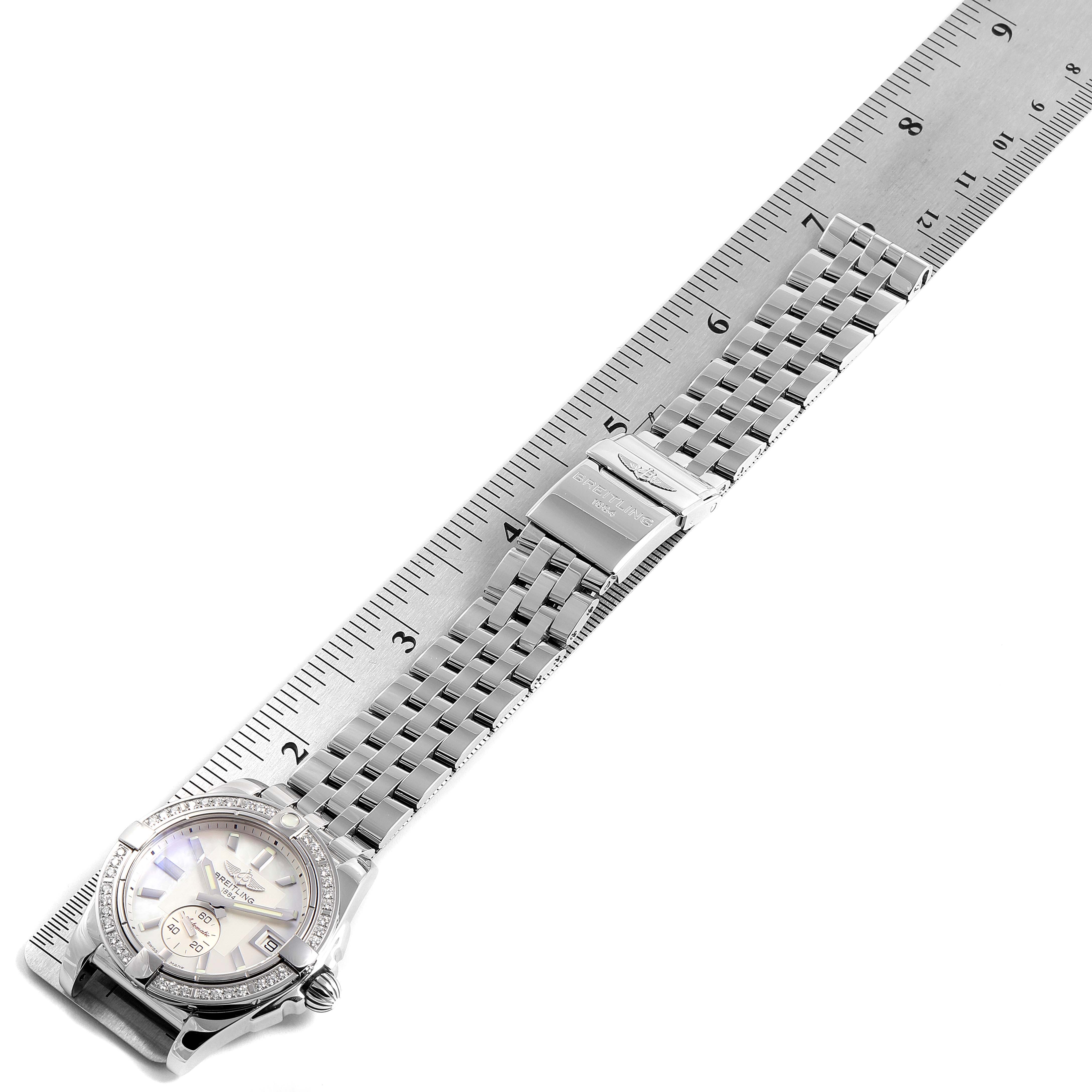 The Breitling A37330 Women's Stainless Steel Mother of Pearl Dial A37330 Women's Stainless Steel Mother of Pearl Dial Galactic 36 Mother of Pearl Diamond Steel Ladies Watch A37330 is shown from a top-down angle alongside a ruler, displaying its face and bracelet.