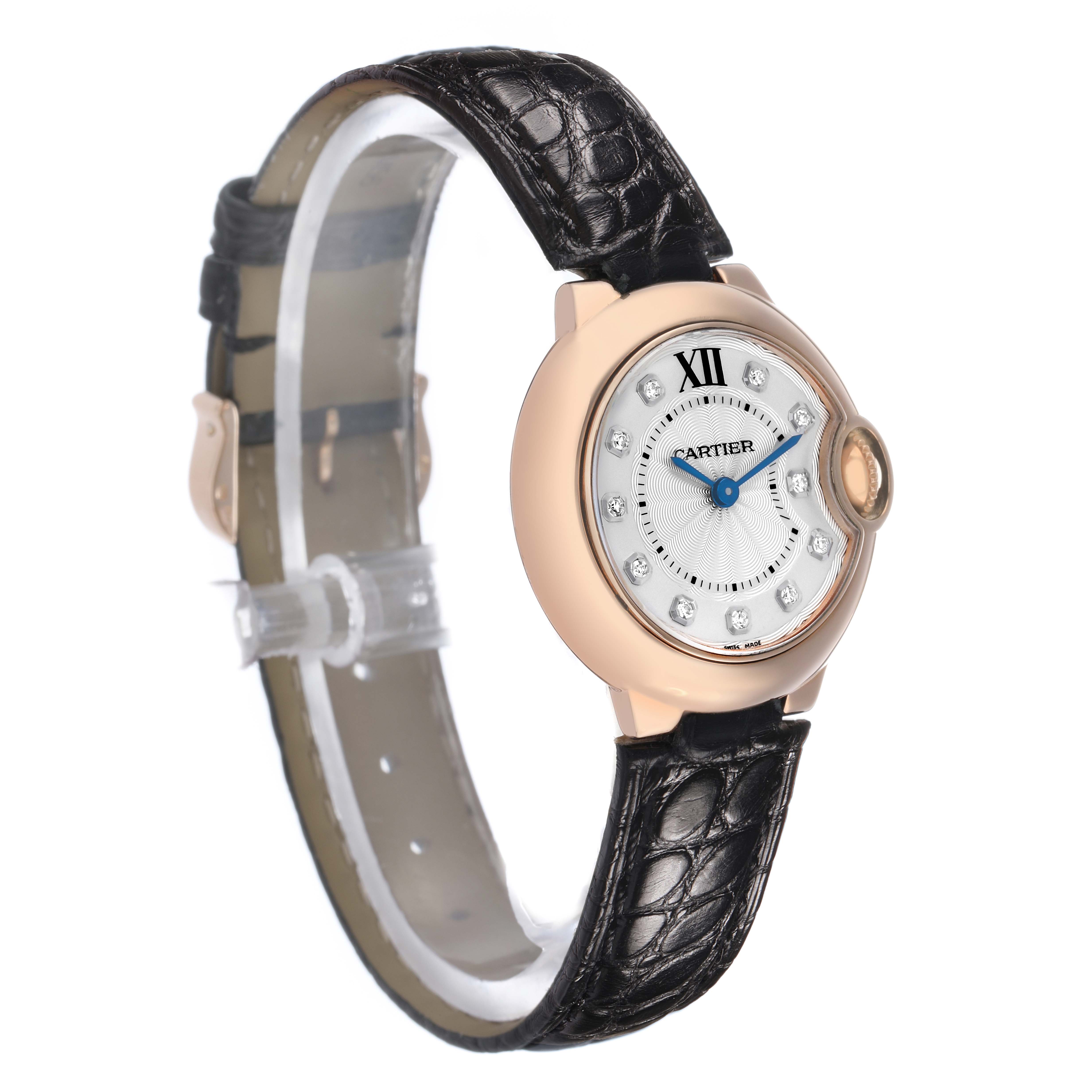 The Cartier Ballon Bleu WE902050 Women's Rose Gold Silver Dial watch is shown at a side angle, highlighting its elegant face, blue hands, and black leather strap.