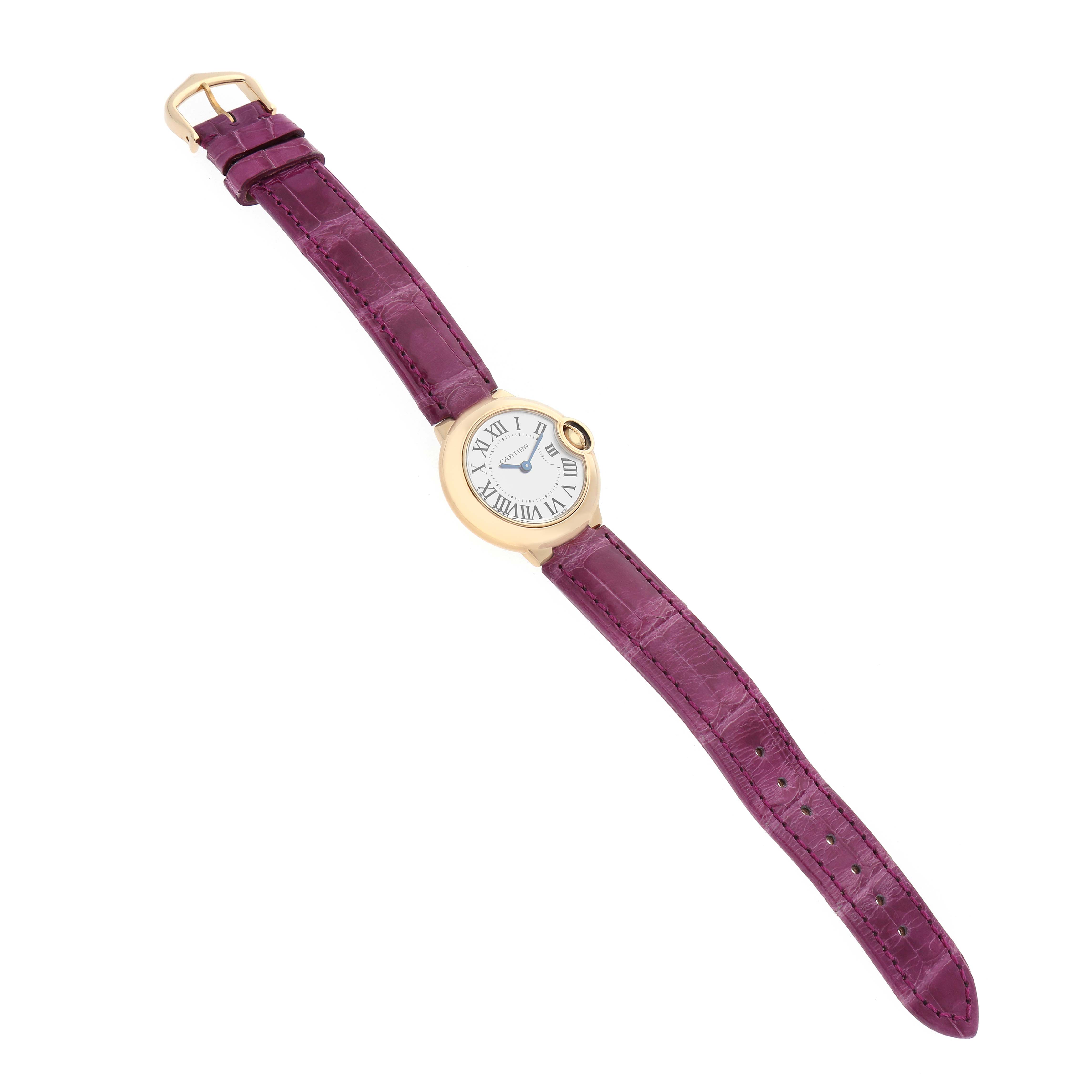 The Cartier Ballon Bleu W6900156 Women's Yellow Gold Silver Dial watch is shown from a front angle with a purple strap and a round gold case.