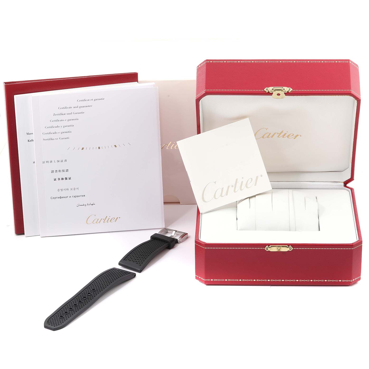 This image shows the accessories of a Calibre de Cartier watch by Cartier, including its box, manuals, and an extra strap.
