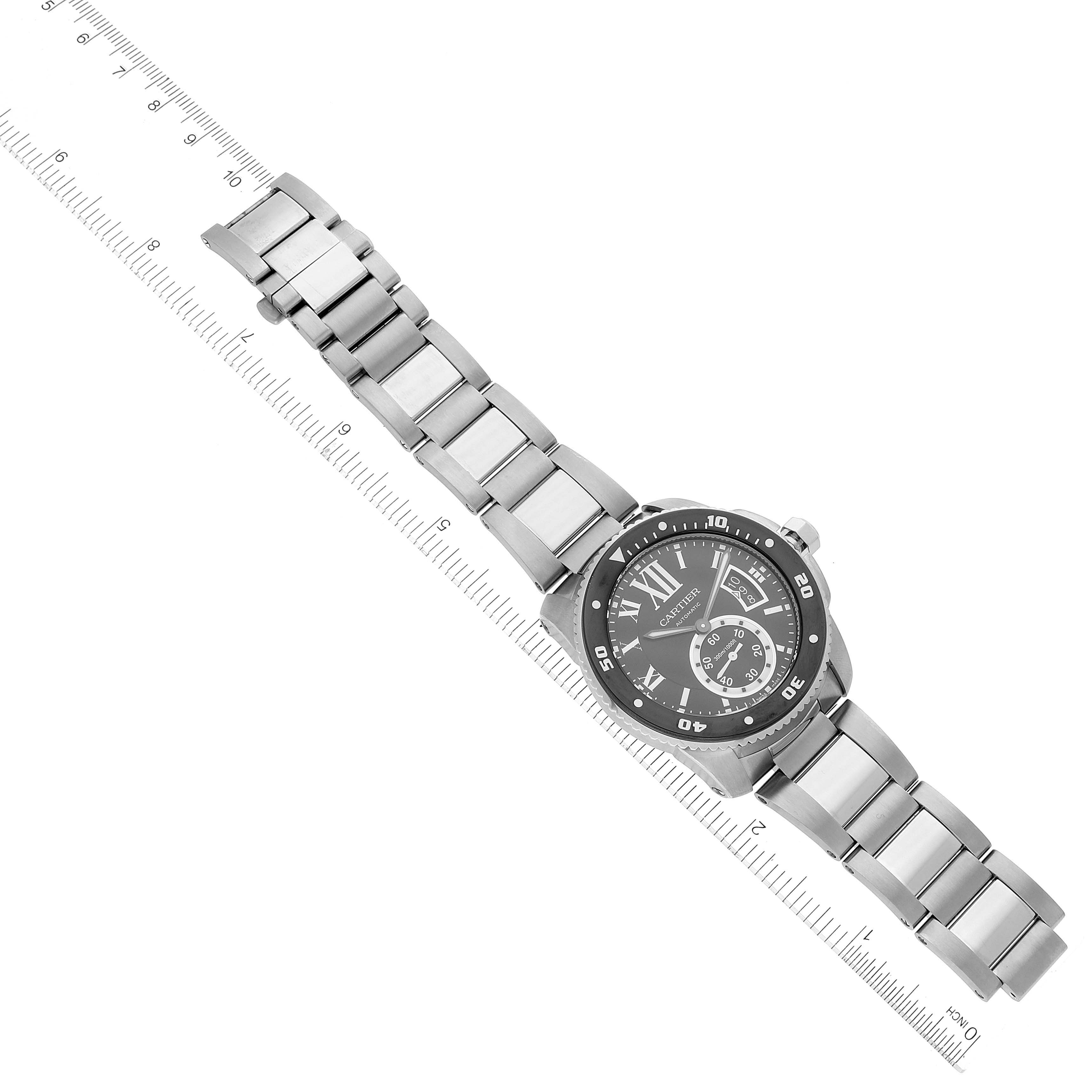 The image shows a full view of a Calibre de Cartier watch by Cartier, including its face, bracelet, and a ruler for scale.