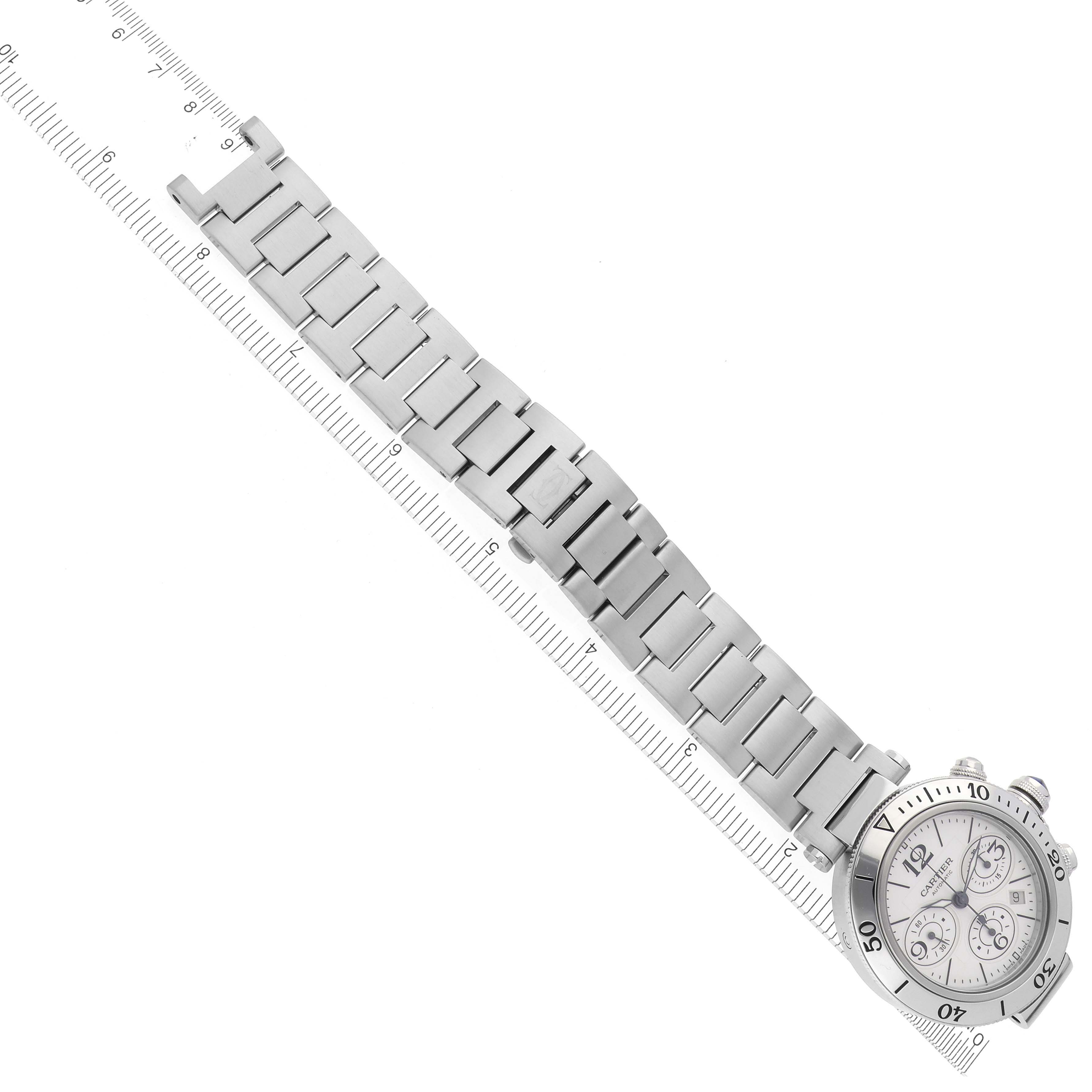 The Cartier Pasha W31089M7 Men's Stainless Steel Silver Dial W31089M7 Men's Stainless Steel Silver Dial watch is shown from an overhead angle, displaying the entire bracelet and face alongside a ruler.
