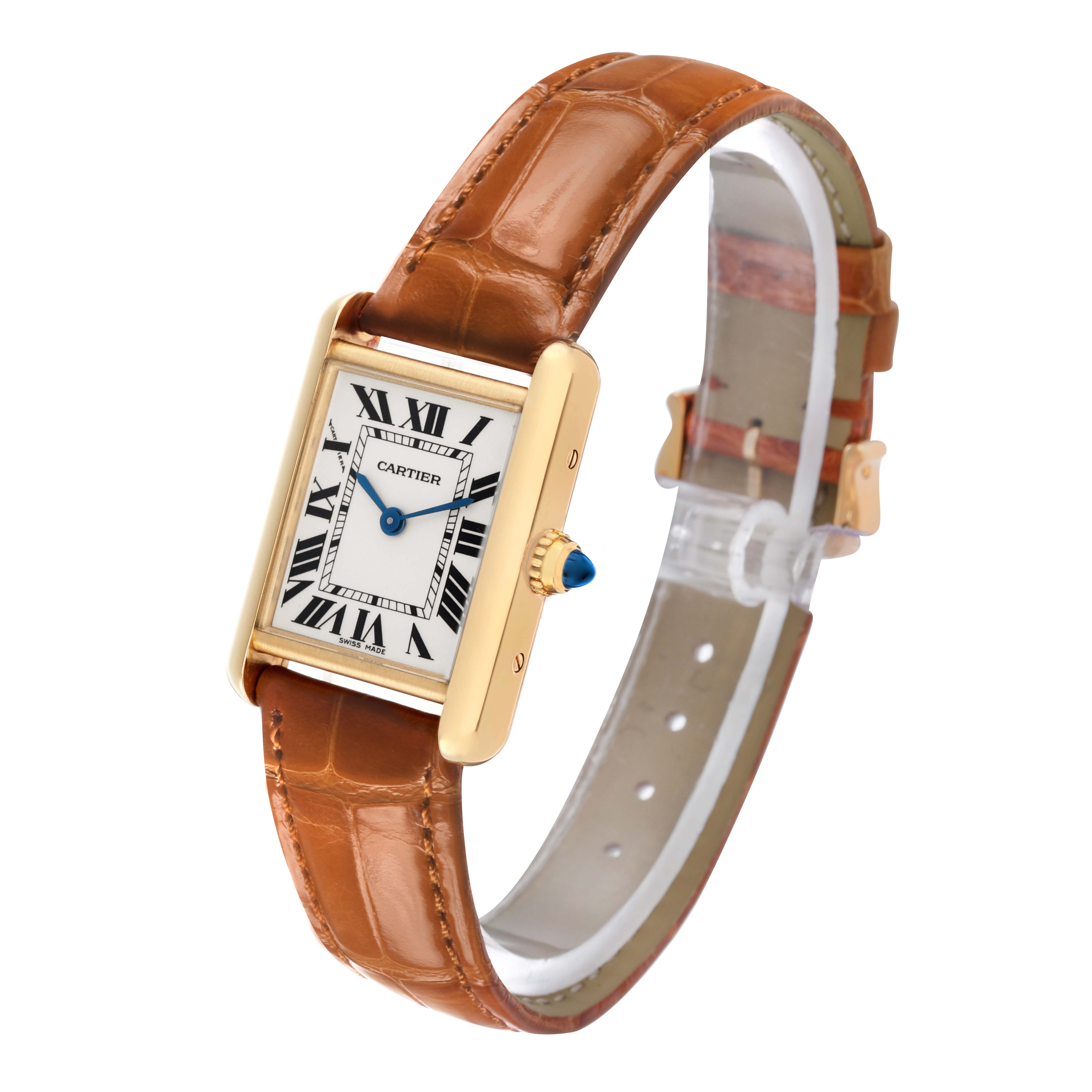 The image shows a Cartier Tank Louis W1529856 Women's Yellow Gold Silver Dial watch angled to display its face, gold casing, leather strap, and blue cabochon crown.