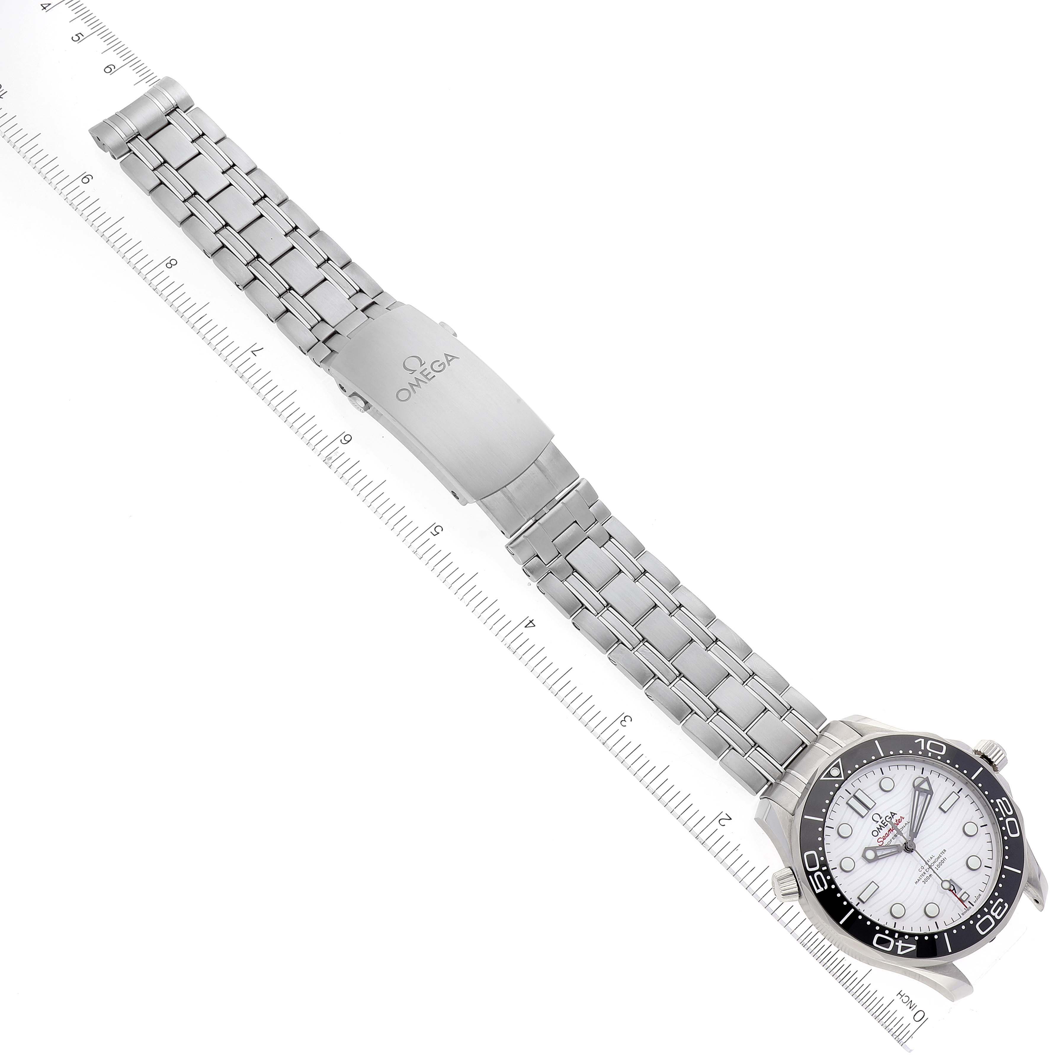 The Omega Seamaster 210.30.42.20.04.001 Men's Stainless Steel White Dial 210.30.42.20.04.001 Men's Stainless Steel White Dial watch is shown from a top-down angle, displaying the entire watch and bracelet alongside a ruler.