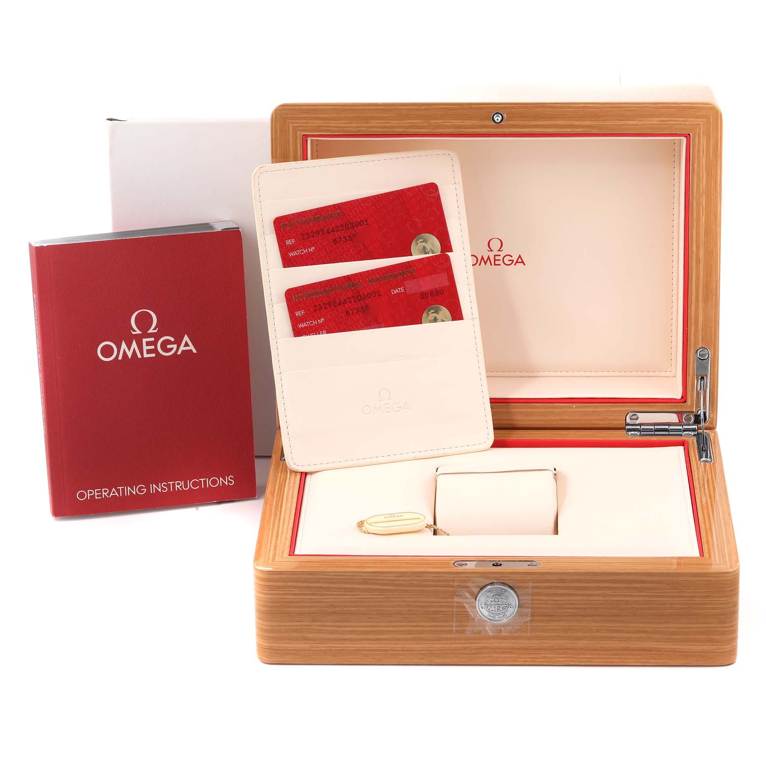 The image shows the open wooden box, operating instructions, and warranty cards for the Omega Planet Ocean 232.92.44.22.03.001 Men
s Stainless Steel Blue Dial 232.92.44.22.03.001 Men
s Stainless Steel Blue Dial watch.