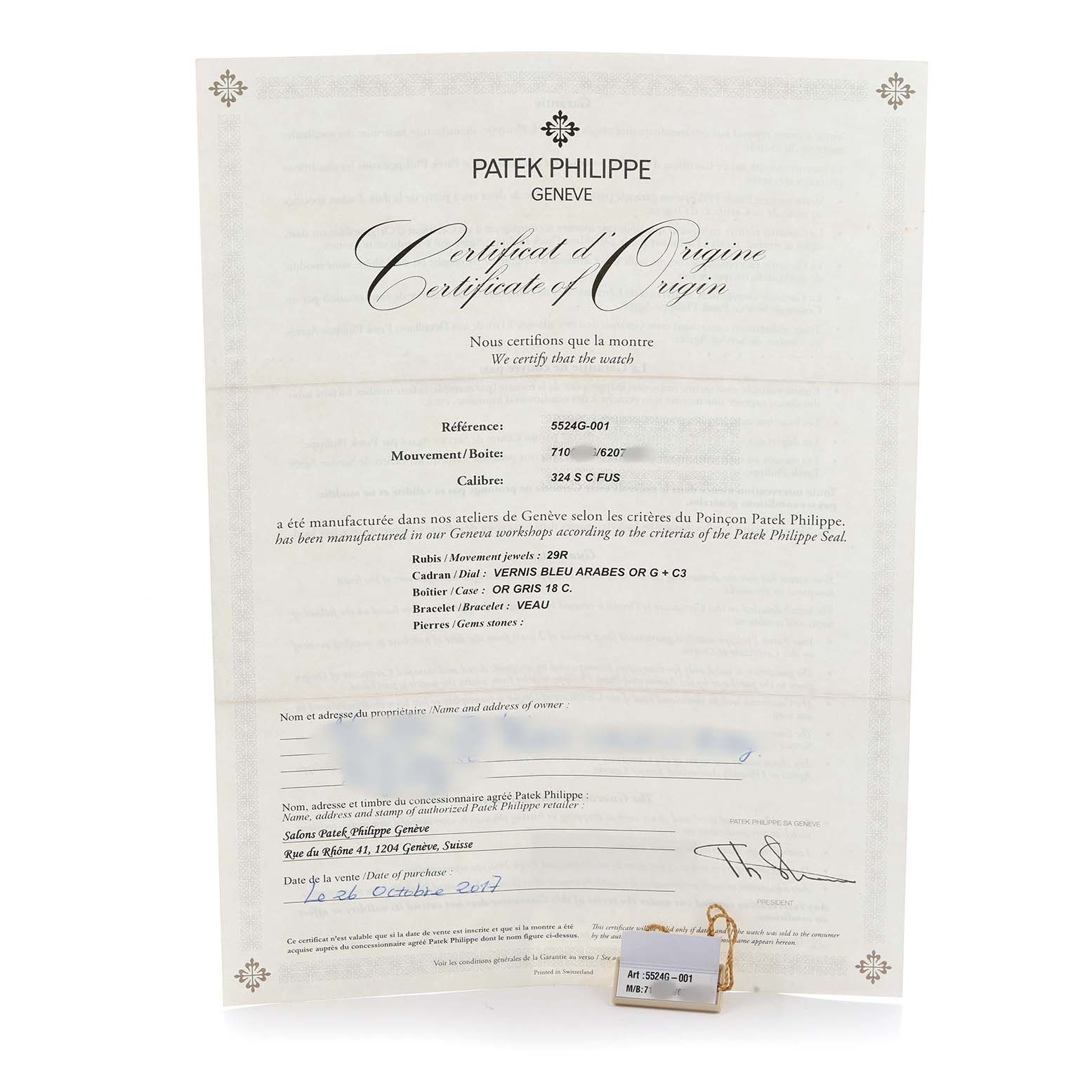 The image shows a Patek Philippe Calatrava 5524G Men's White Gold Blue Dial certificate of origin, highlighting watch details, with a small tag attached.