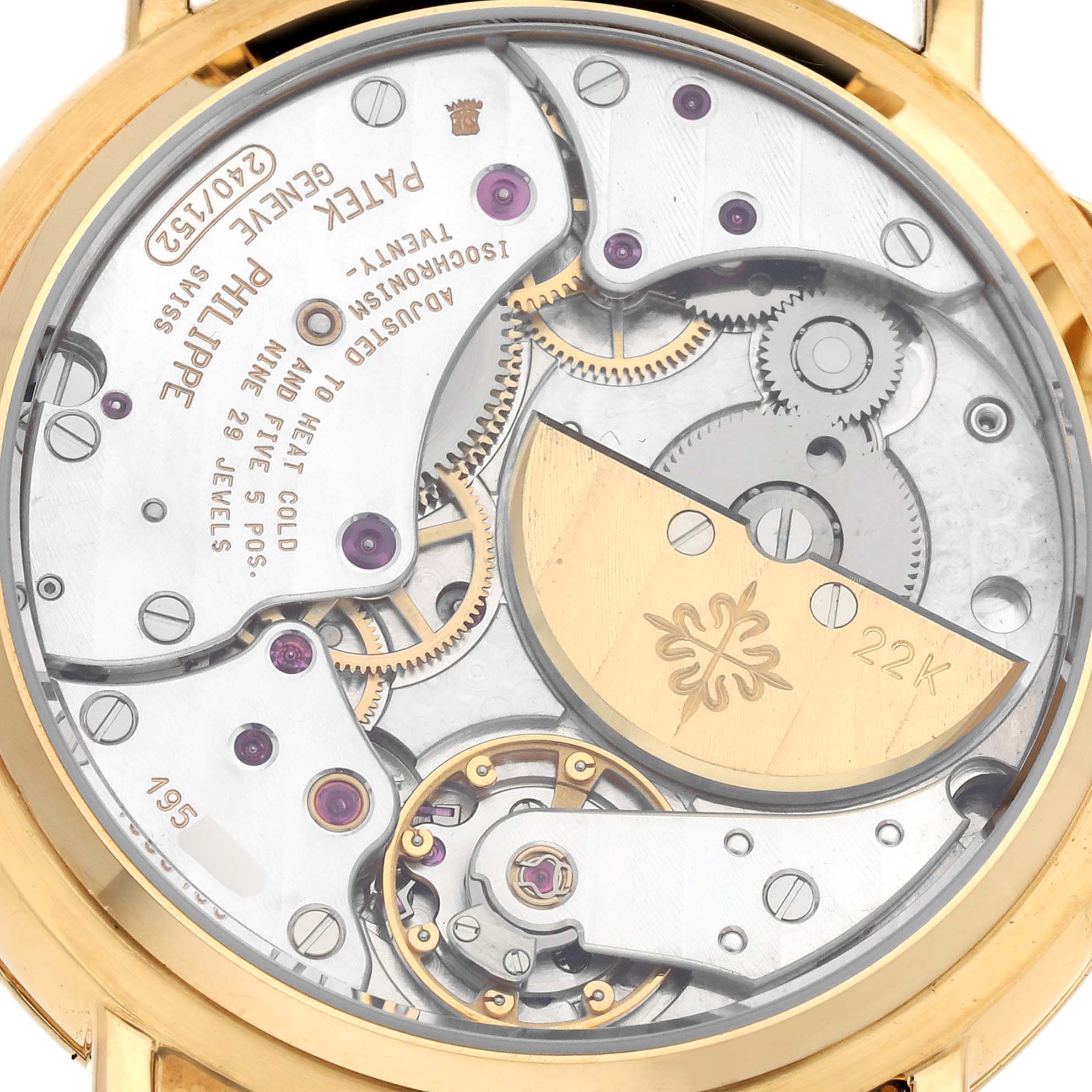 The image shows a close-up of the Patek Philippe Calatrava 5015J-001 Men's Yellow Gold White Dial 5015J-001 Men's Yellow Gold White Dial movement from a rear angle, highlighting the intricate gears and 22K rotor.