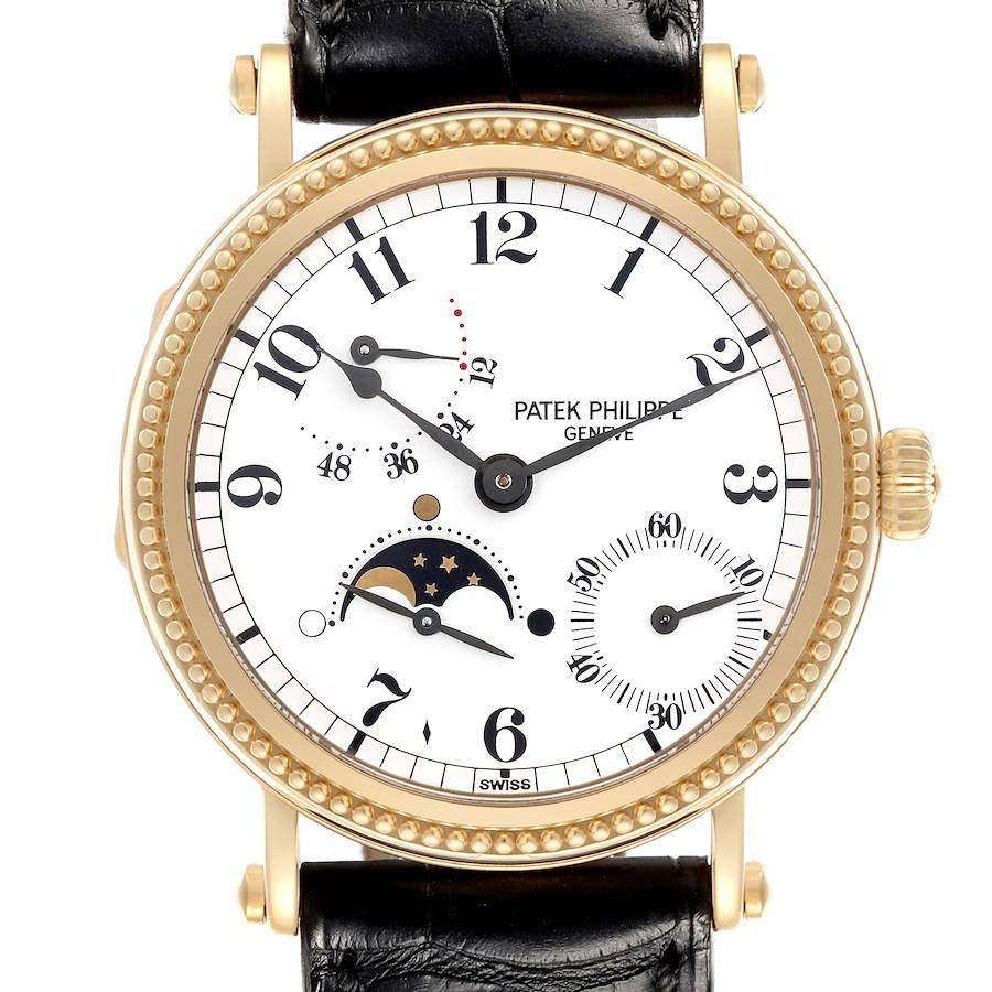 The Patek Philippe Calatrava watch is shown from the front, displaying its dial, moon phase, and subdials, with a black leather strap.