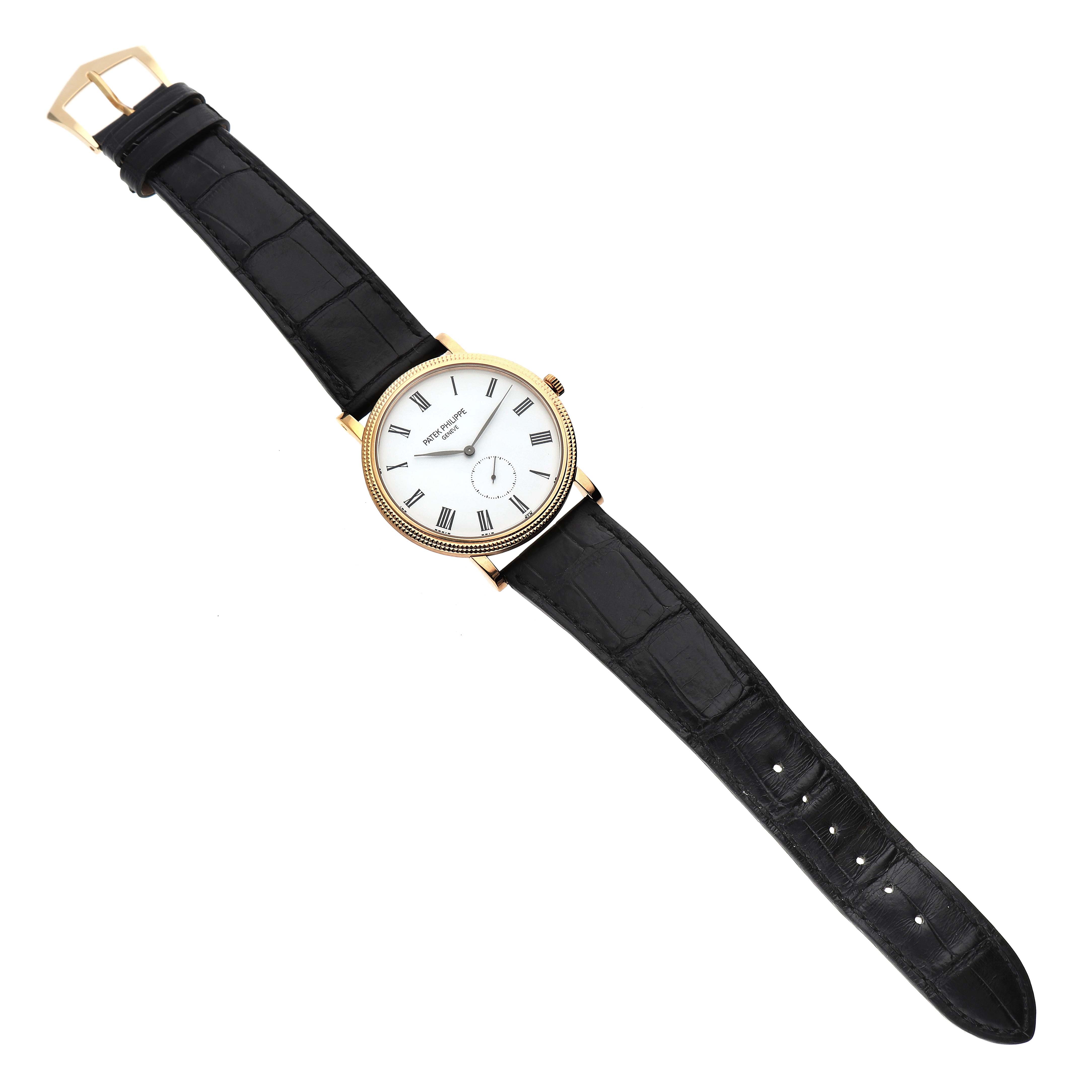 The Patek Philippe Calatrava 5119J-001 Men's Yellow Gold White Dial watch is shown from a top-down angle, displaying the entire watch face, strap, and buckle.