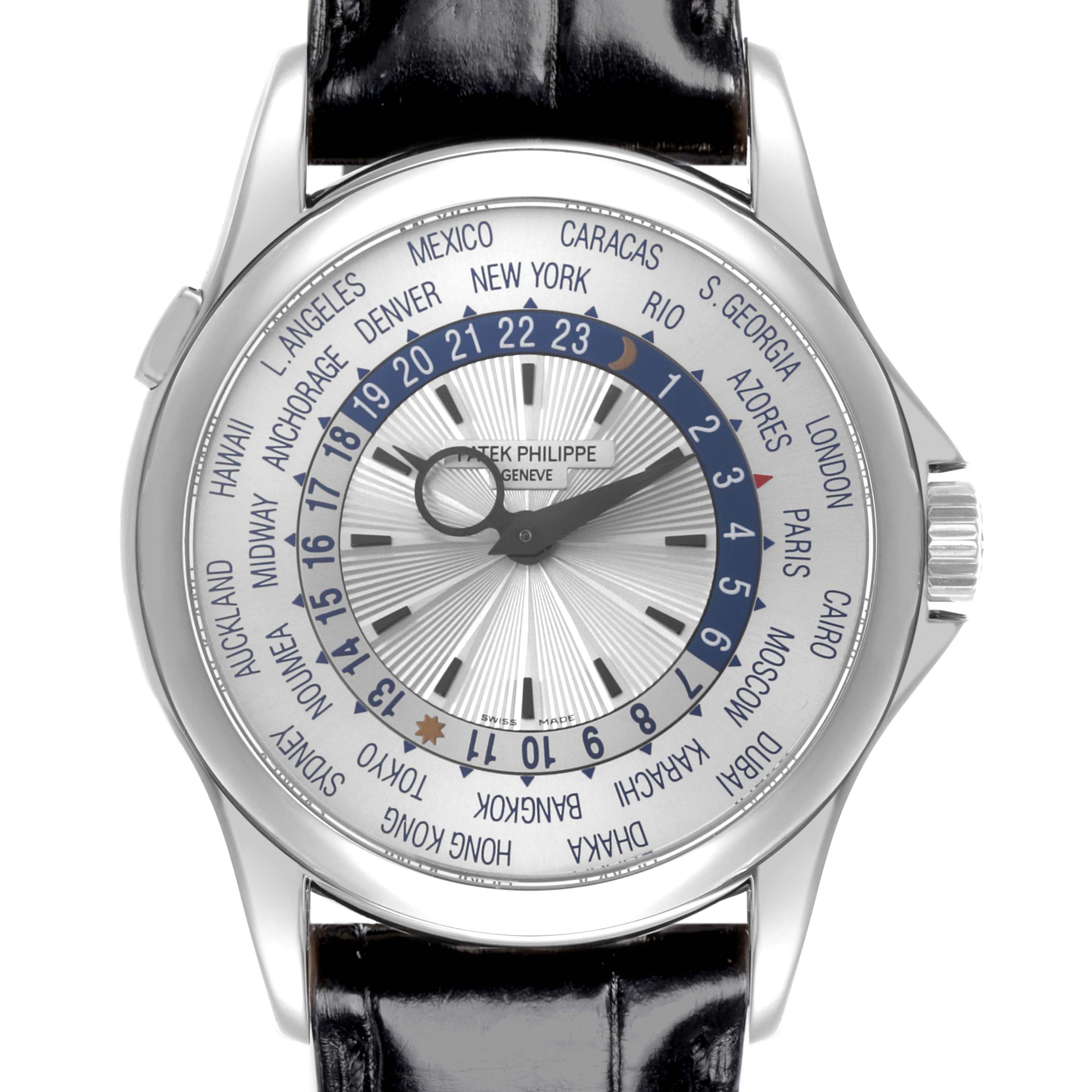 The Patek Philippe Complications 5130G Men
s White Gold Silver Dial 5130G Men
s White Gold Silver Dial watch is shown from the front, displaying the dial with world time zones and a leather strap.