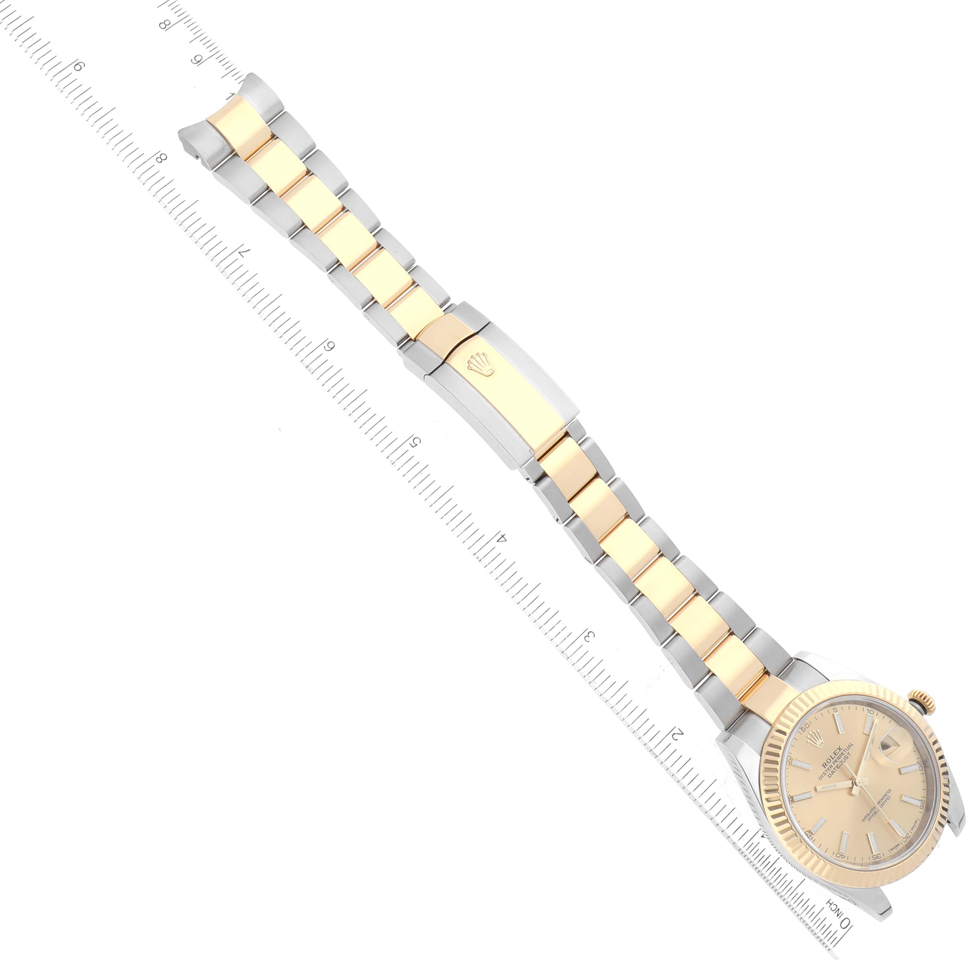 The image shows a top-down view of a Rolex Datejust 41 126333 Men's Steel and Gold (two tone) Champagne Dial 126333 Men's Steel and Gold (two tone) Champagne Dial watch, featuring its gold and silver bracelet, face, and clasp alongside a ruler for scale.