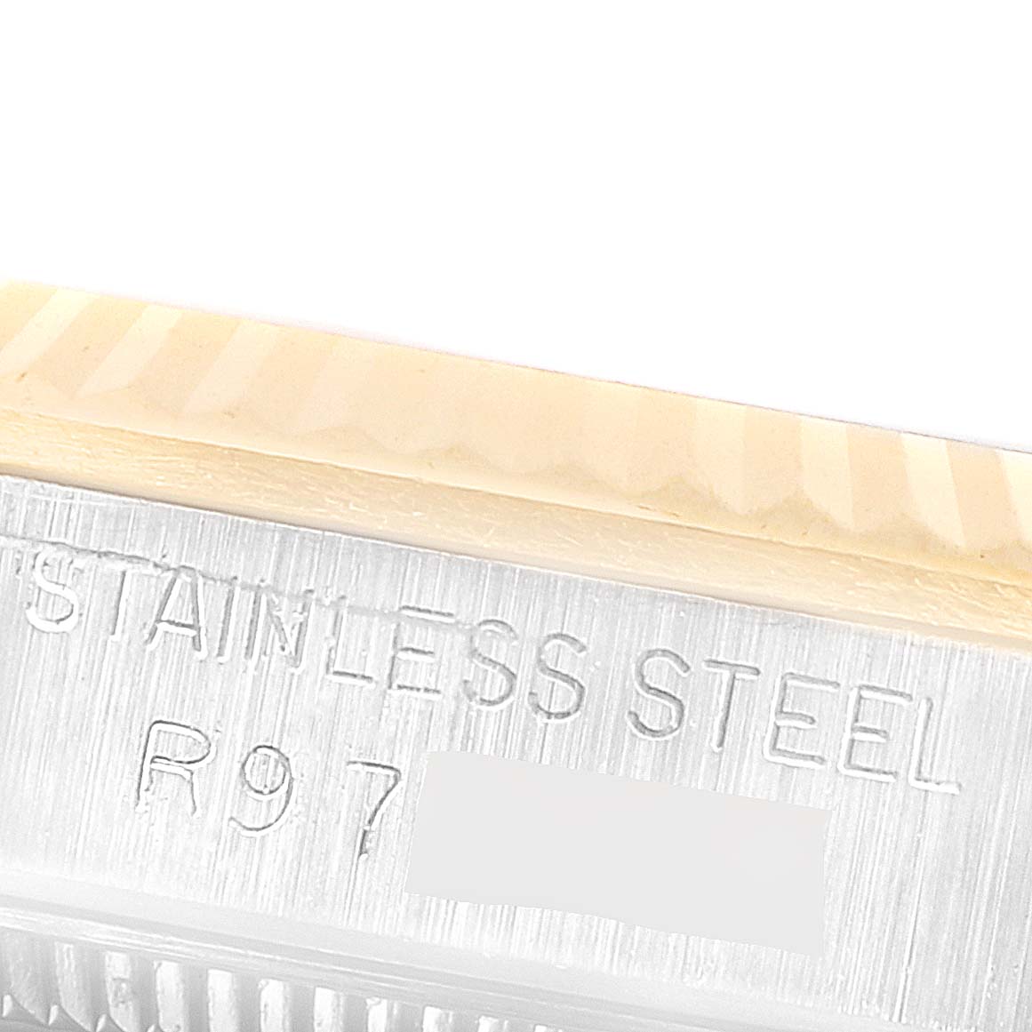 The image shows a close-up of the serial number engraving on the stainless steel mid-size Rolex watch case.