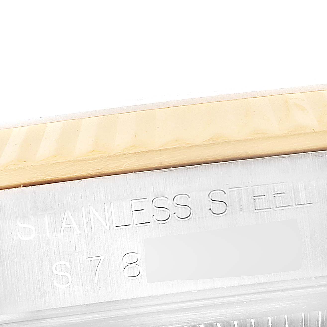 This image shows a close-up of the engraved stainless steel part of a Rolex Datejust 16233 Men's Steel and Gold (two tone) Champagne Dial 16233 Men's Steel and Gold (two tone) Champagne Dial watch case, with a partial view of the bezel.