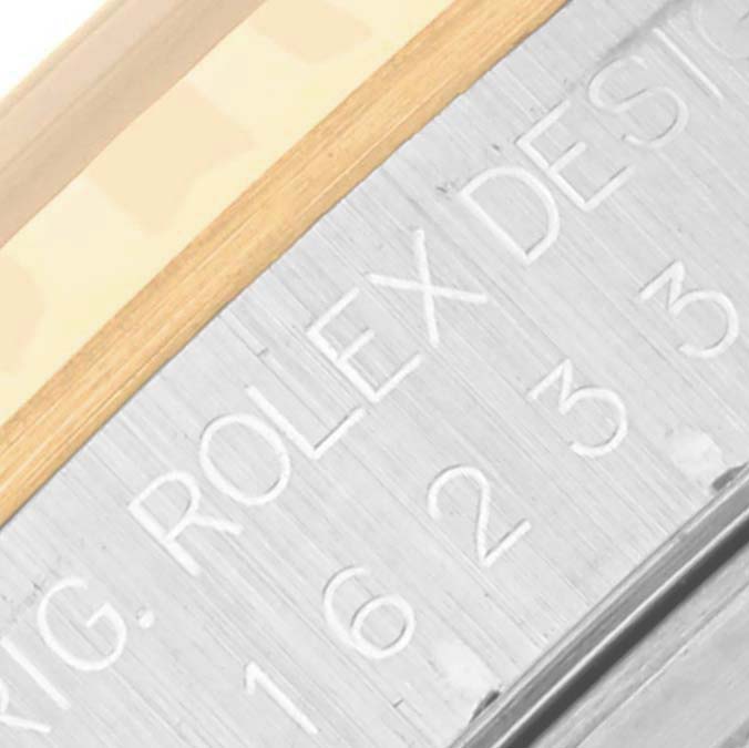 The image shows the side engraving of the Rolex Datejust 16233 Men's Steel and Gold (two tone) Blue Dial 16233 Men's Steel and Gold (two tone) Blue Dial's case edge, featuring part of the model number and design text.