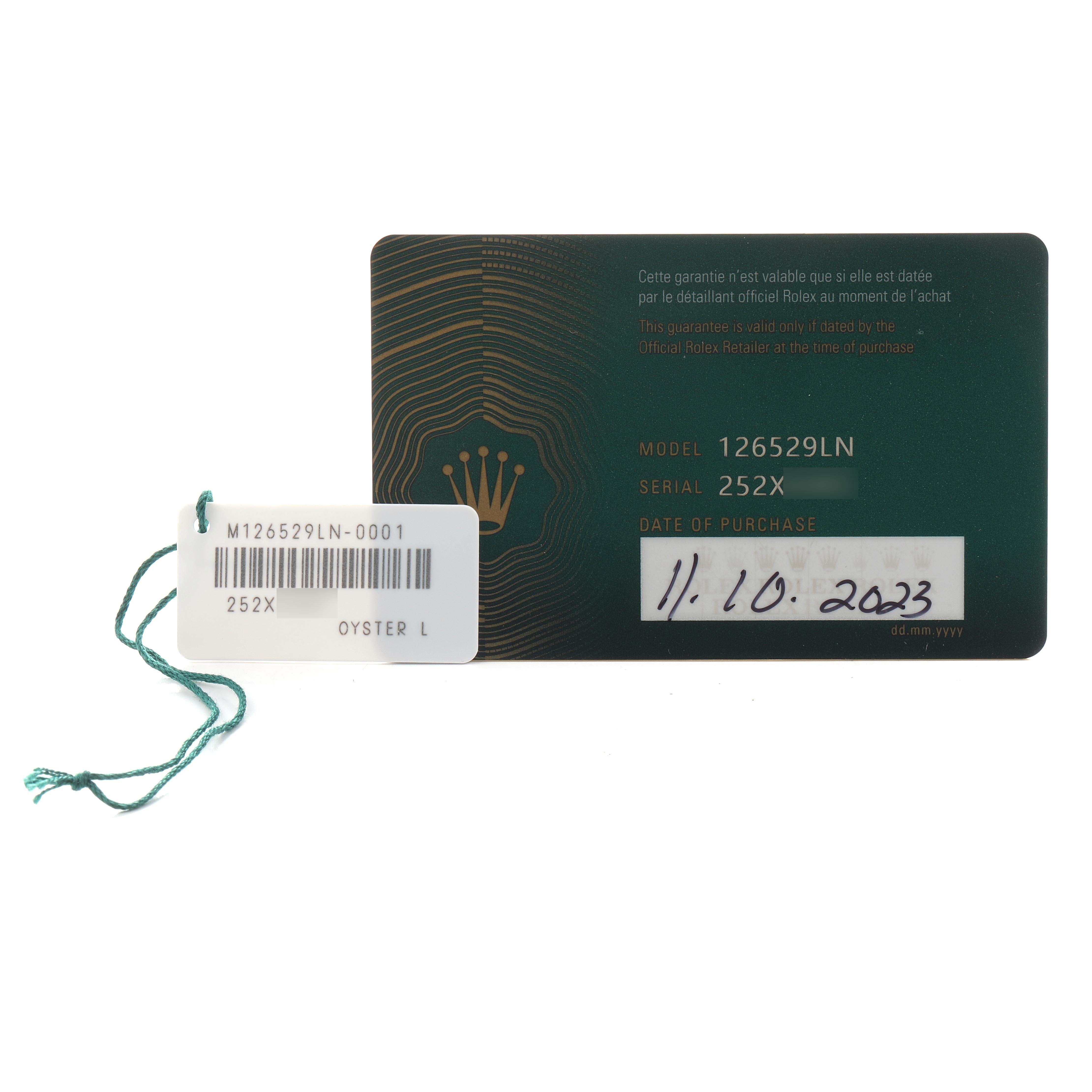 The image shows a Rolex Daytona 126529LN Men's White Gold Black Dial warranty card alongside a tag with model and serial numbers.