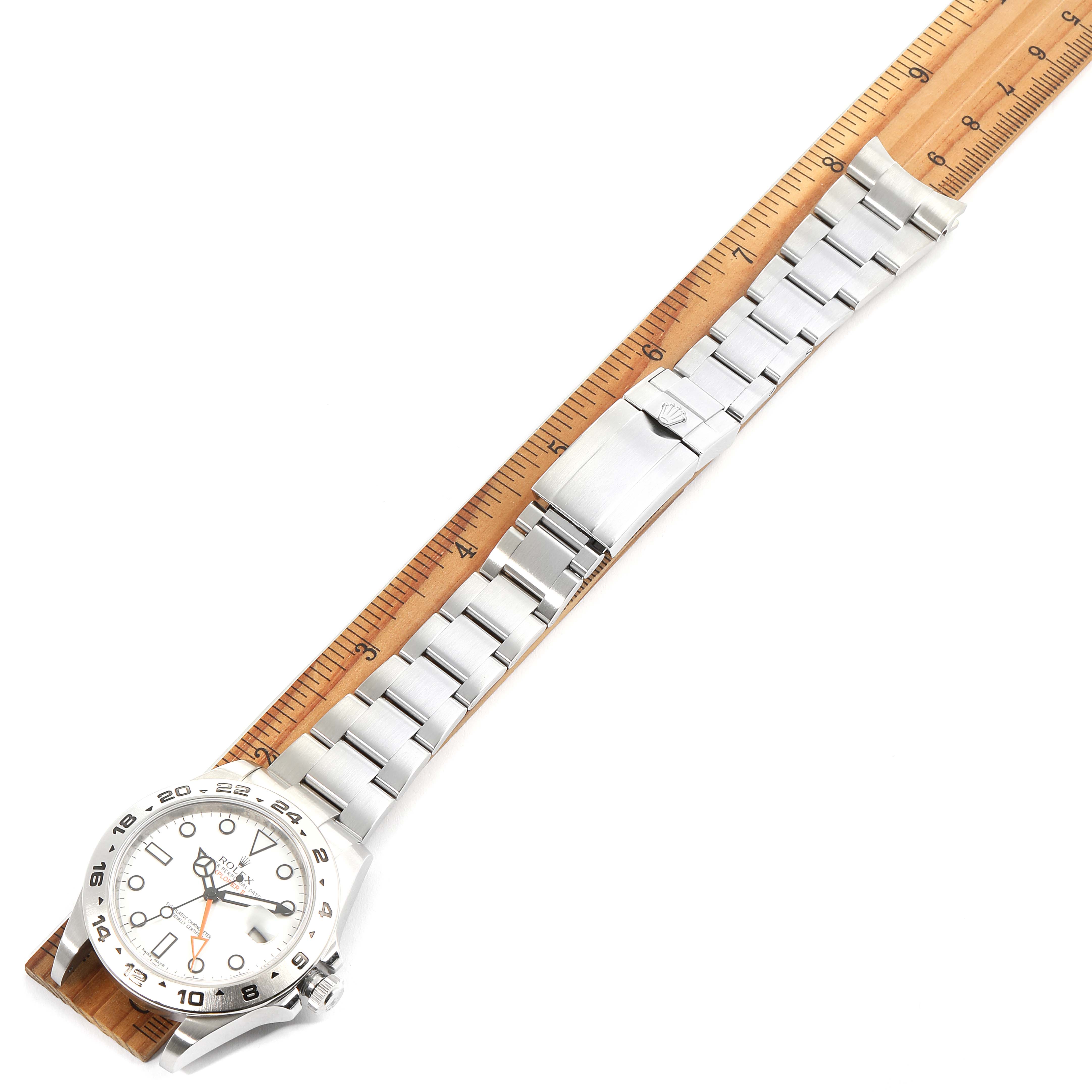 The image shows a Rolex Explorer 216570 Men
s Stainless Steel White Dial 216570 Men
s Stainless Steel White Dial watch laid flat with a ruler beside it, displaying the face and bracelet.