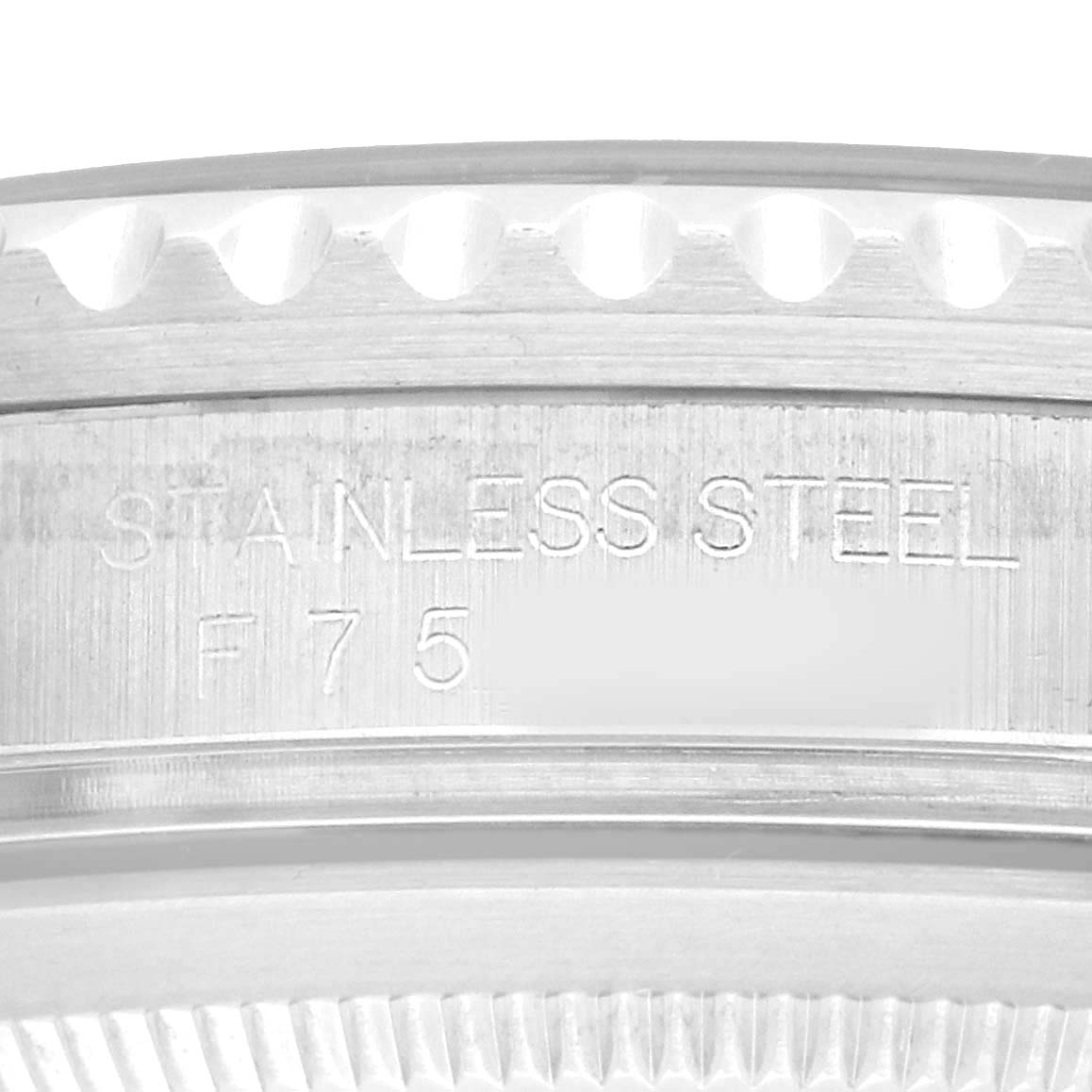 The image shows a close-up of the engraved side of a Rolex GMT-Master 16710 Men's Stainless Steel Black Dial's stainless steel bezel and case.