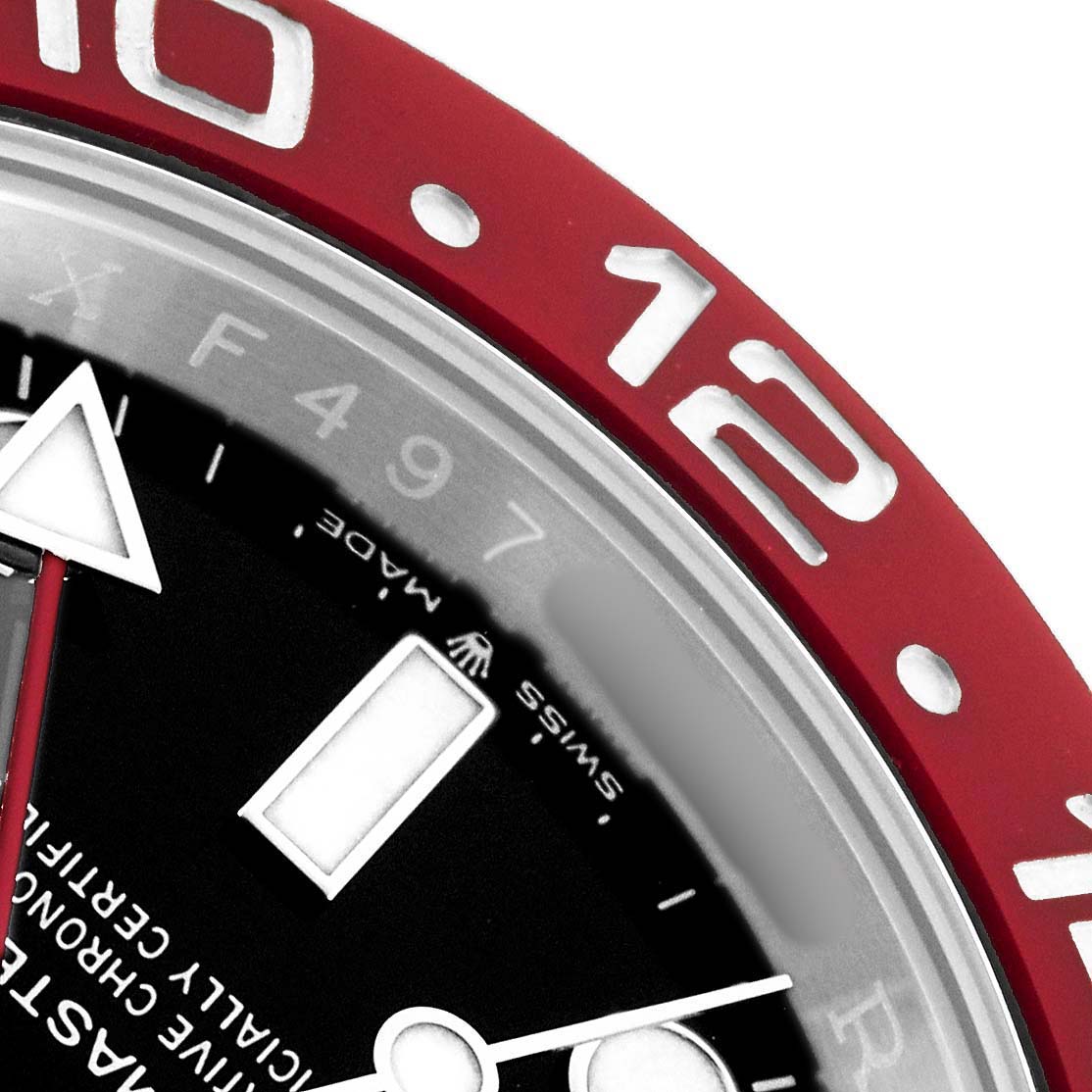 This image shows a close-up of the Rolex GMT-Master 126710 Men's Stainless Steel Black Dial's red bezel and part of the dial, highlighting the 10 and 12 markers.