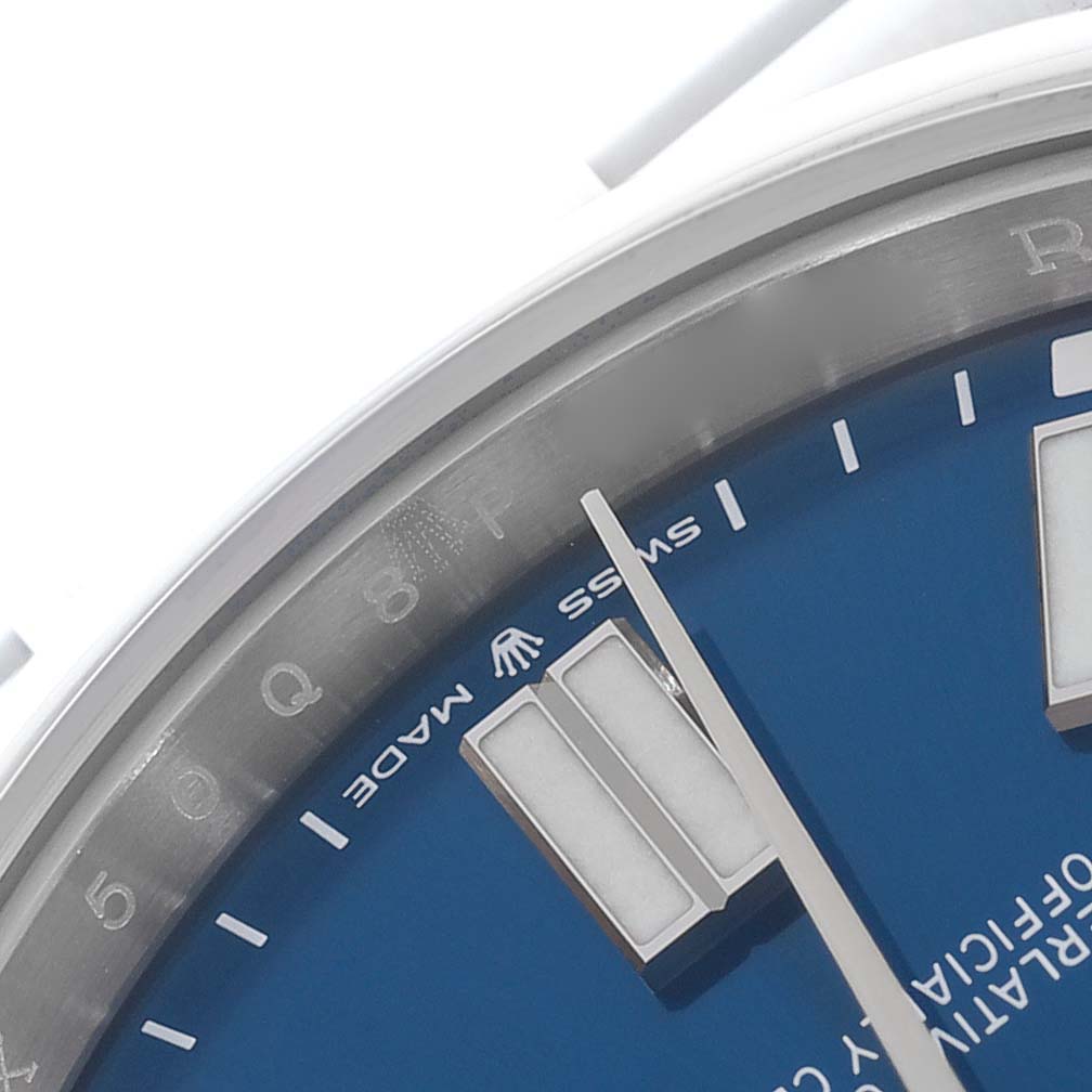 The image shows a close-up of the dial and bezel of a Rolex Oyster Perpetual 124300 Men's Stainless Steel Blue Dial 124300 Men's Stainless Steel Blue Dial, highlighting the blue face and hour markers.