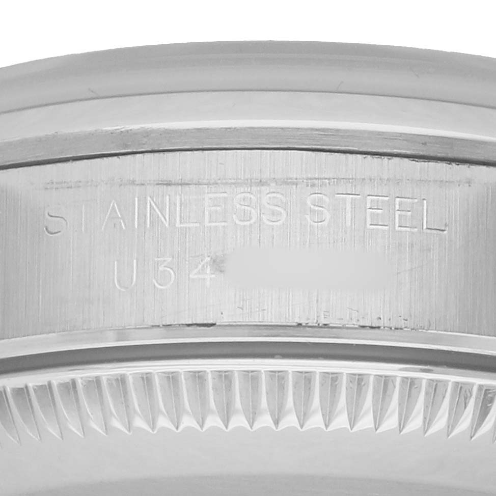 The image shows a close-up of the case back edge of a Rolex Oyster Perpetual 67180 Women's Stainless Steel Pink Dial, highlighting the "STAINLESS STEEL" engraving.