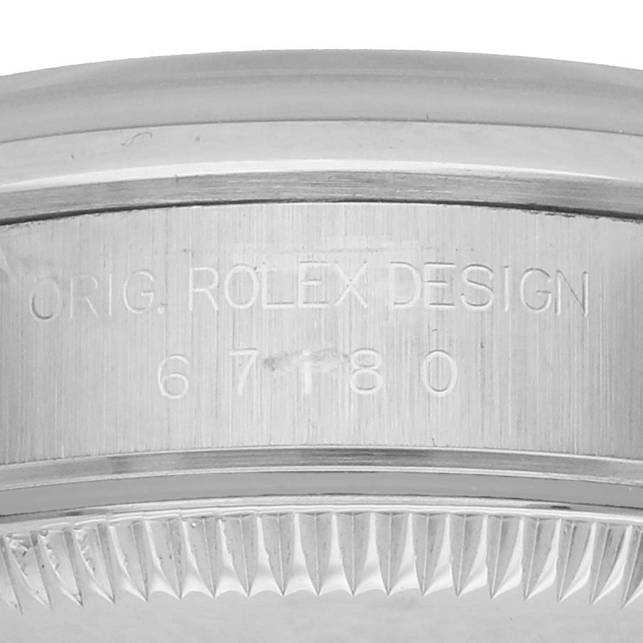 The image shows the side view of the Rolex Oyster Perpetual 67180 Women's Stainless Steel Pink Dial model bezel, highlighting the "Orig. Rolex Design" engraving and reference number.