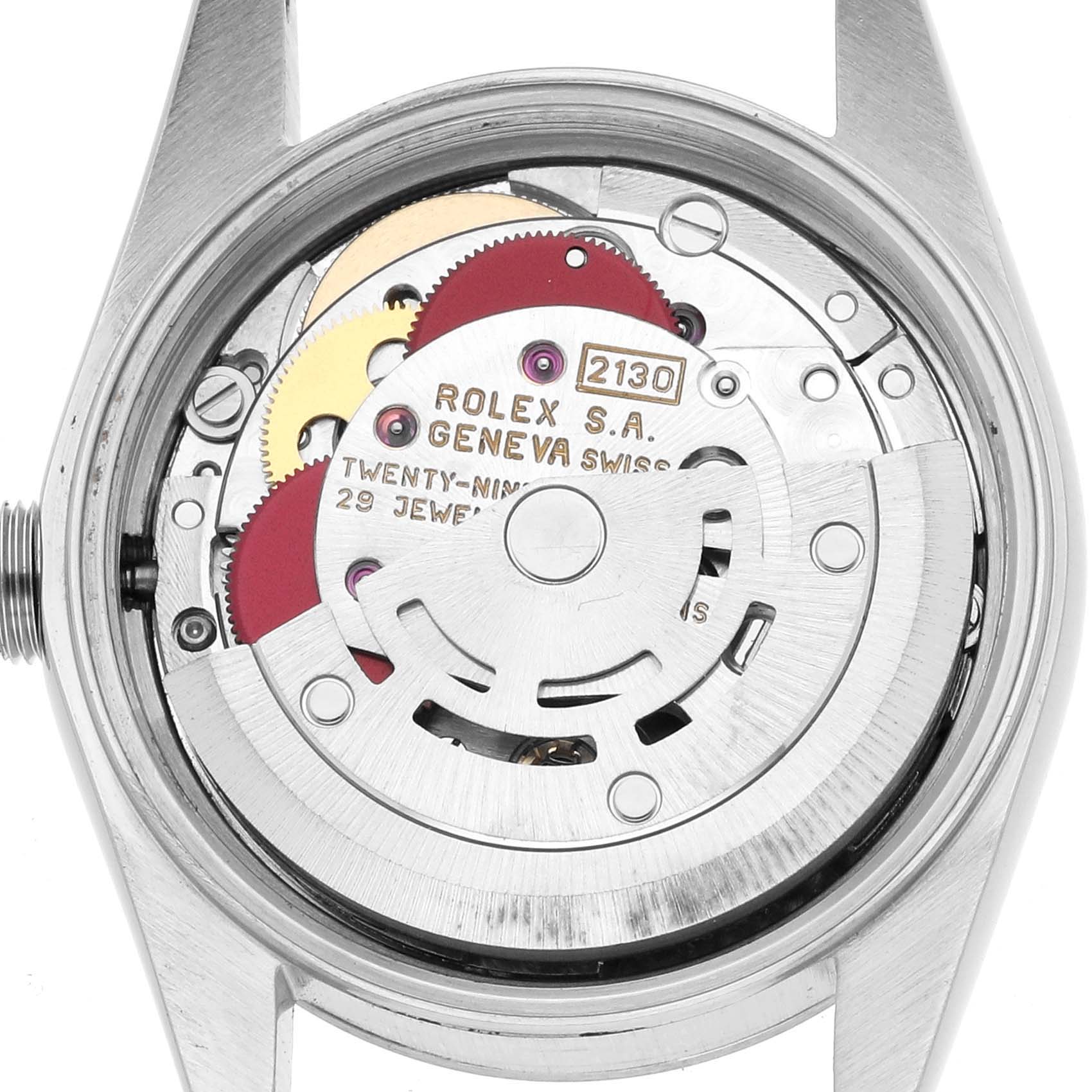 The image shows the movement of a Rolex Oyster Perpetual 67180 Women's Stainless Steel Pink Dial watch, focusing on its intricate internal components from a top-down view.