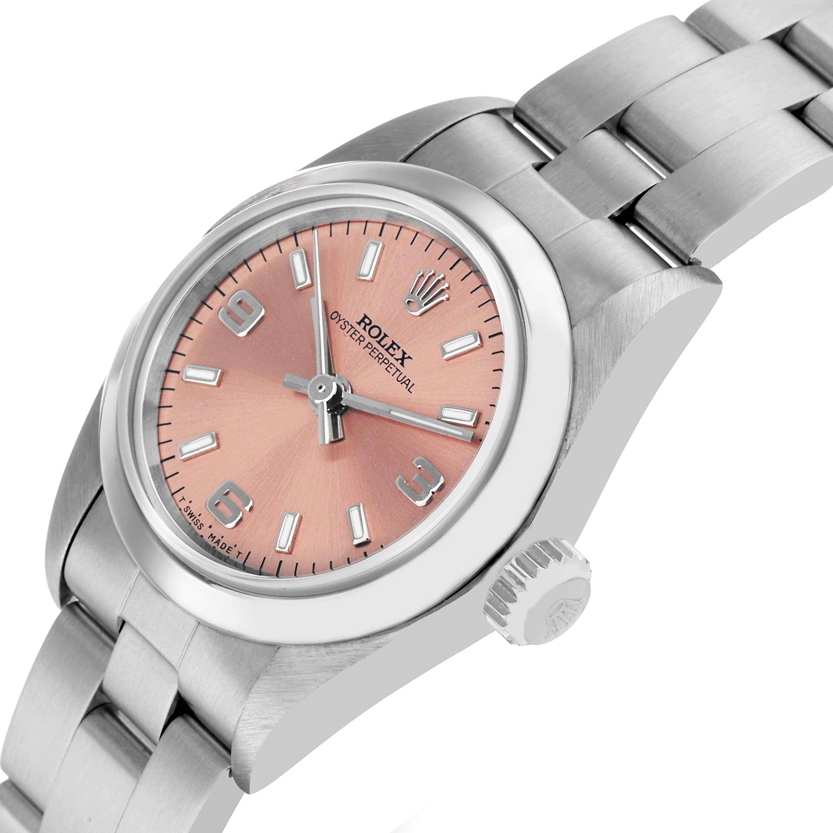 The Rolex Oyster Perpetual 67180 Women's Stainless Steel Pink Dial watch is shown at a three-quarter angle, highlighting its salmon dial, crown, and stainless steel bracelet.