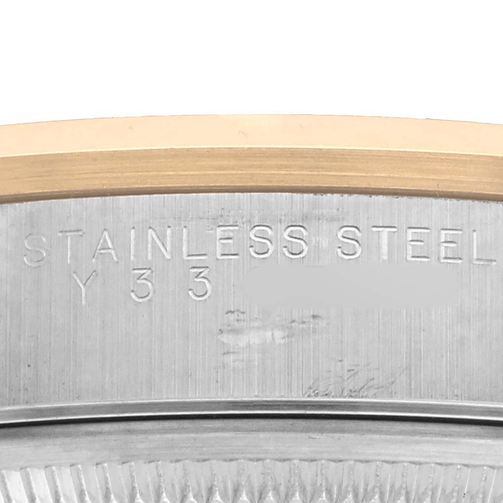 The image shows a close-up of the case side of a Rolex Oyster Perpetual 14203 Men's Steel and Gold (two tone) Black Dial with "STAINLESS STEEL" engraved on it.