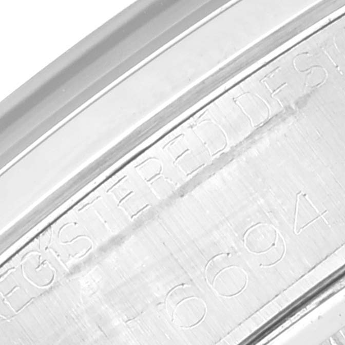 This image shows a close-up of the engraved serial number and text on the case edge of a Rolex Vintage Collection 6694 Men's Stainless Steel Silver Dial 6694 Men's Stainless Steel Silver Dial model watch.