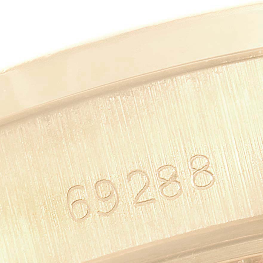 This image shows a close-up of the serial number engraved on the band of a Rolex President 69288 Women's Yellow Gold Green Dial 69288 Women's Yellow Gold Green Dial model watch.