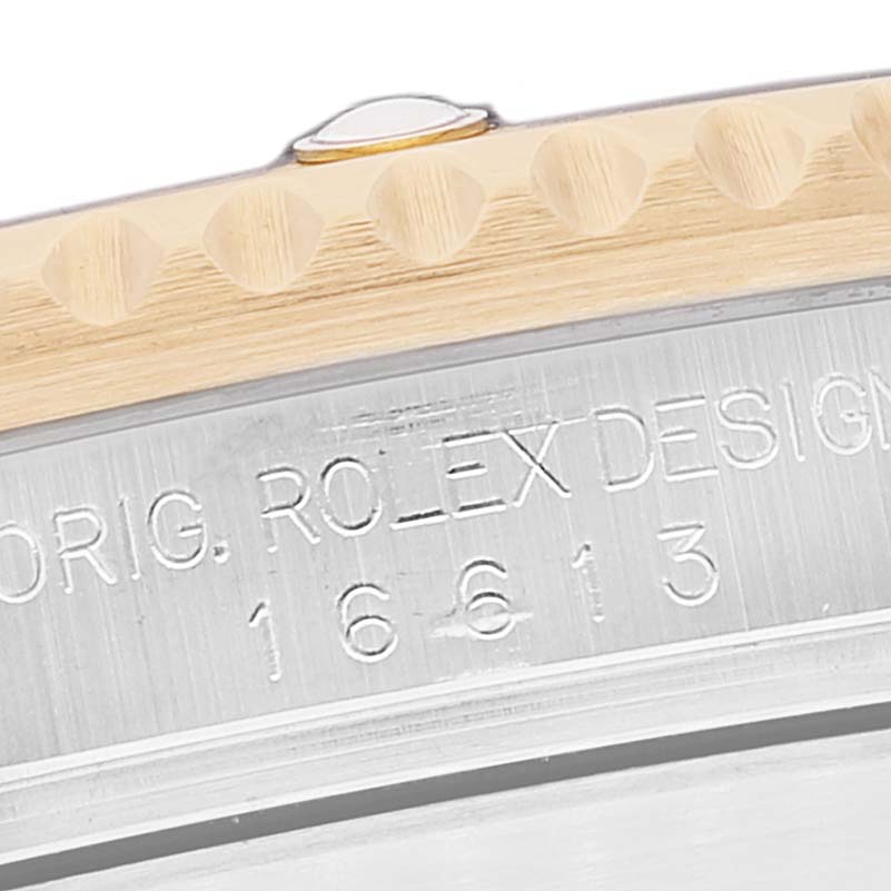 This image shows a close-up of the engraving on the side of a Rolex Submariner 16613 Men's Steel and Gold (two tone) Black Dial 16613 Men's Steel and Gold (two tone) Black Dial model 16613, highlighting the bezel and case.