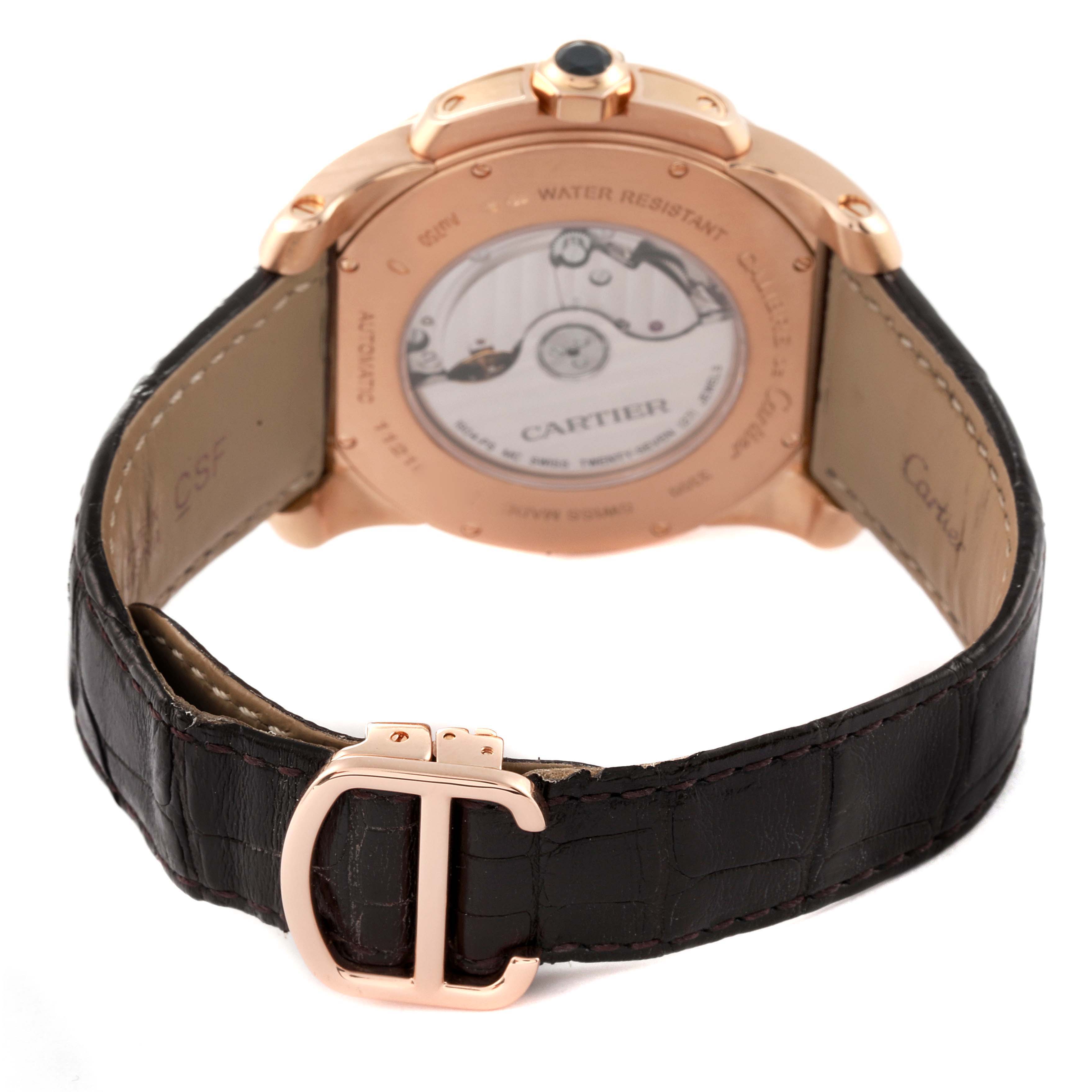 The image shows the back view of a Calibre de Cartier watch by Cartier, highlighting the case back, leather strap, and buckle.