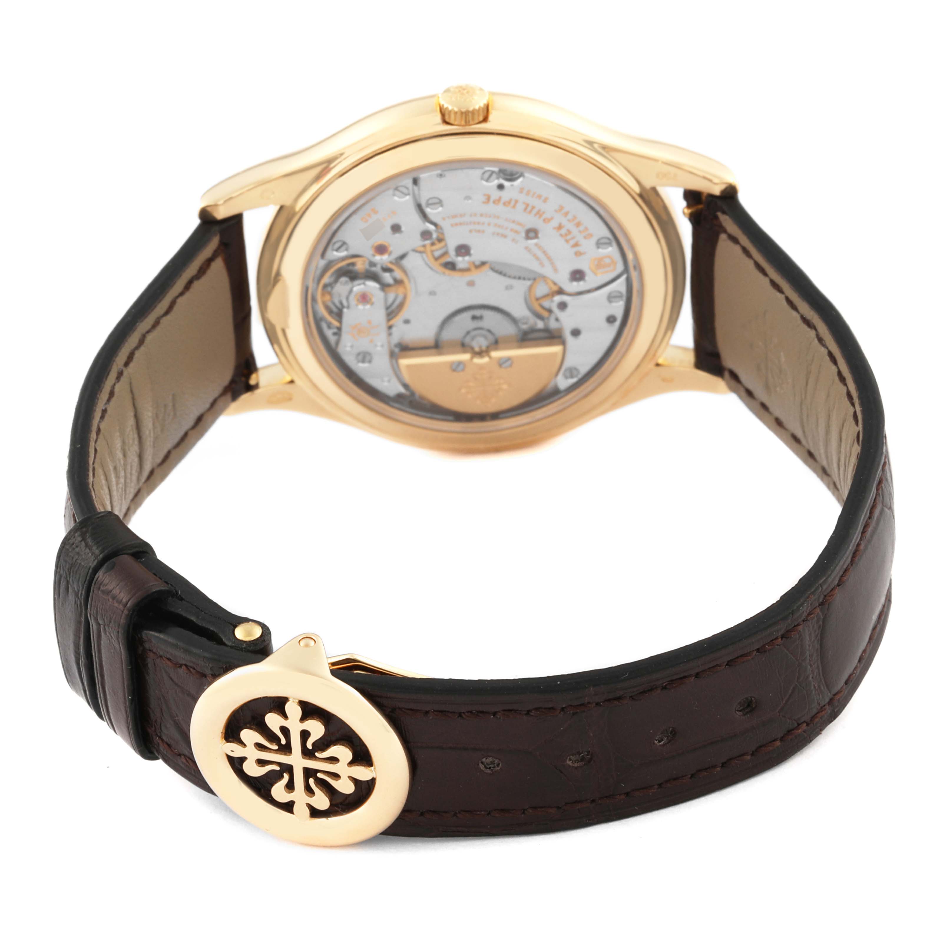 The image shows the back of a Patek Philippe Calatrava 5140J-001 Men
s Yellow Gold Silver Dial 5140J-001 Men
s Yellow Gold Silver Dial watch, highlighting the movement and leather strap with a decorative clasp.