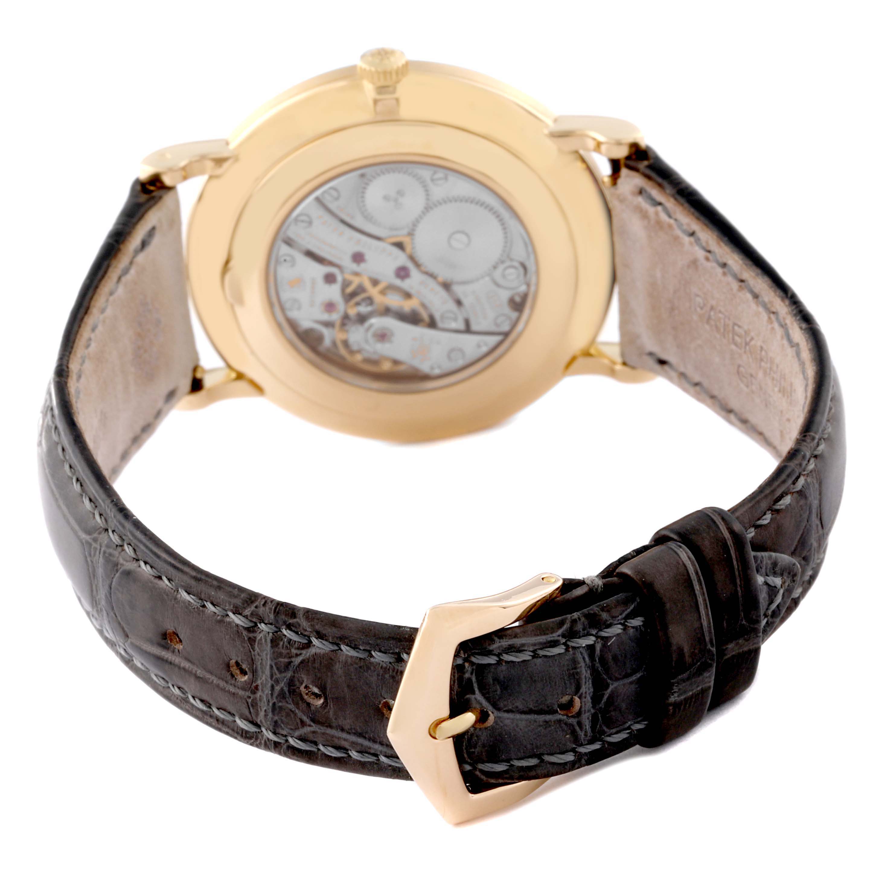 The image shows the back view of a Patek Philippe Calatrava 5119J Men's Yellow Gold White Dial 5119J Men's Yellow Gold White Dial watch, highlighting its movement and leather strap.