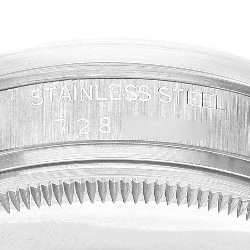 The image shows a close-up of the bezel and the edge of the case back of a Rolex Vintage Collection 15000 Men's Stainless Steel White Dial 15000 Men's Stainless Steel White Dial watch, highlighting the stainless steel engraving.