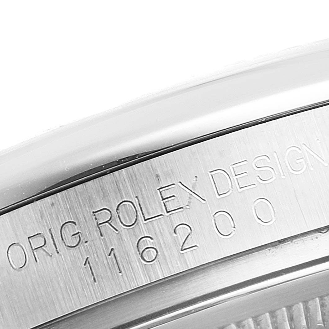 The image shows a close-up of the side of the case on a Rolex Datejust 116200 Men's Stainless Steel Silver Dial 116200 Men's Stainless Steel Silver Dial model with engraved text "ORIG. ROLEX DESIGN 116200."