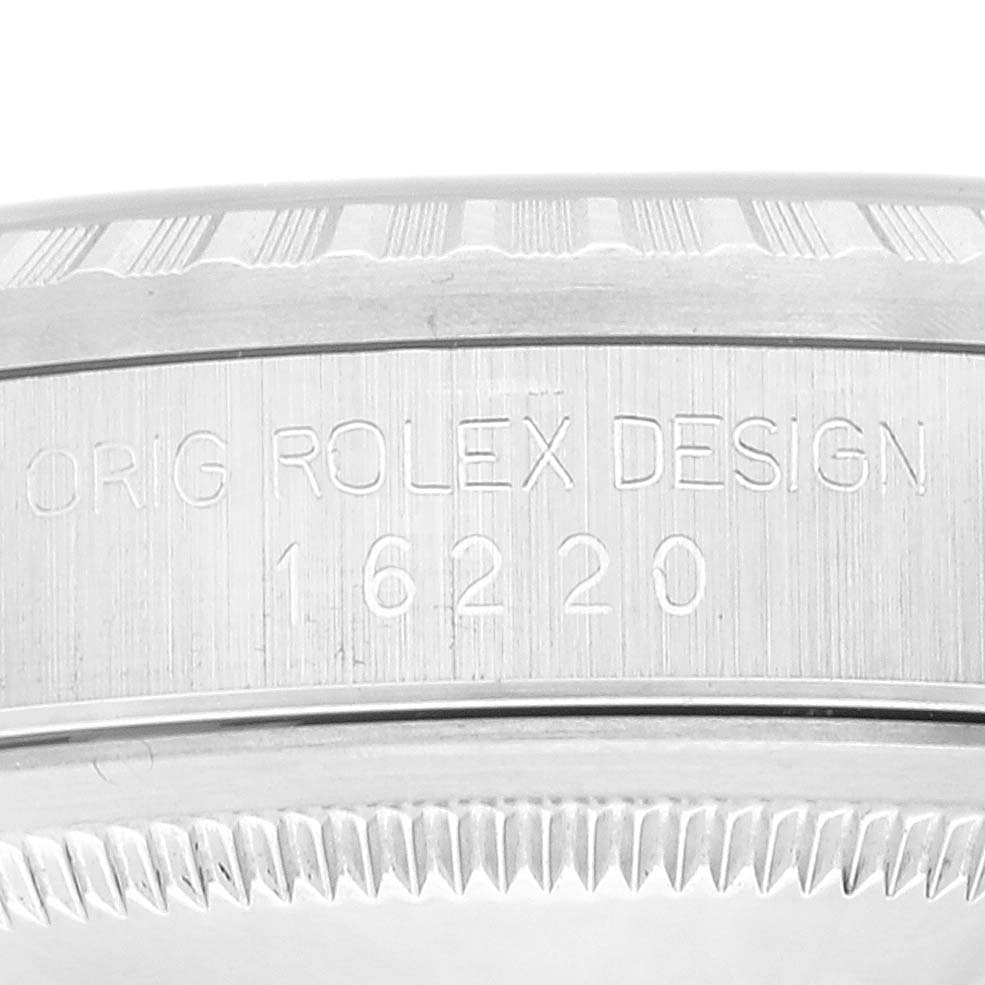 The image shows an up-close view of the side of a Rolex Datejust 16220 Men's Stainless Steel White Dial 16220 Men's Stainless Steel White Dial model, focusing on the serial number and fluted bezel.