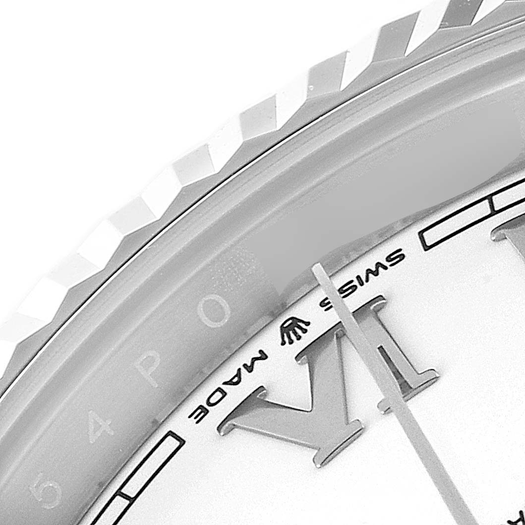 This close-up image of a Rolex Datejust 41 126334 Men
s Stainless Steel White Dial 126334 Men
s Stainless Steel White Dial watch shows its fluted bezel and part of the dial with the Swiss Made inscription.