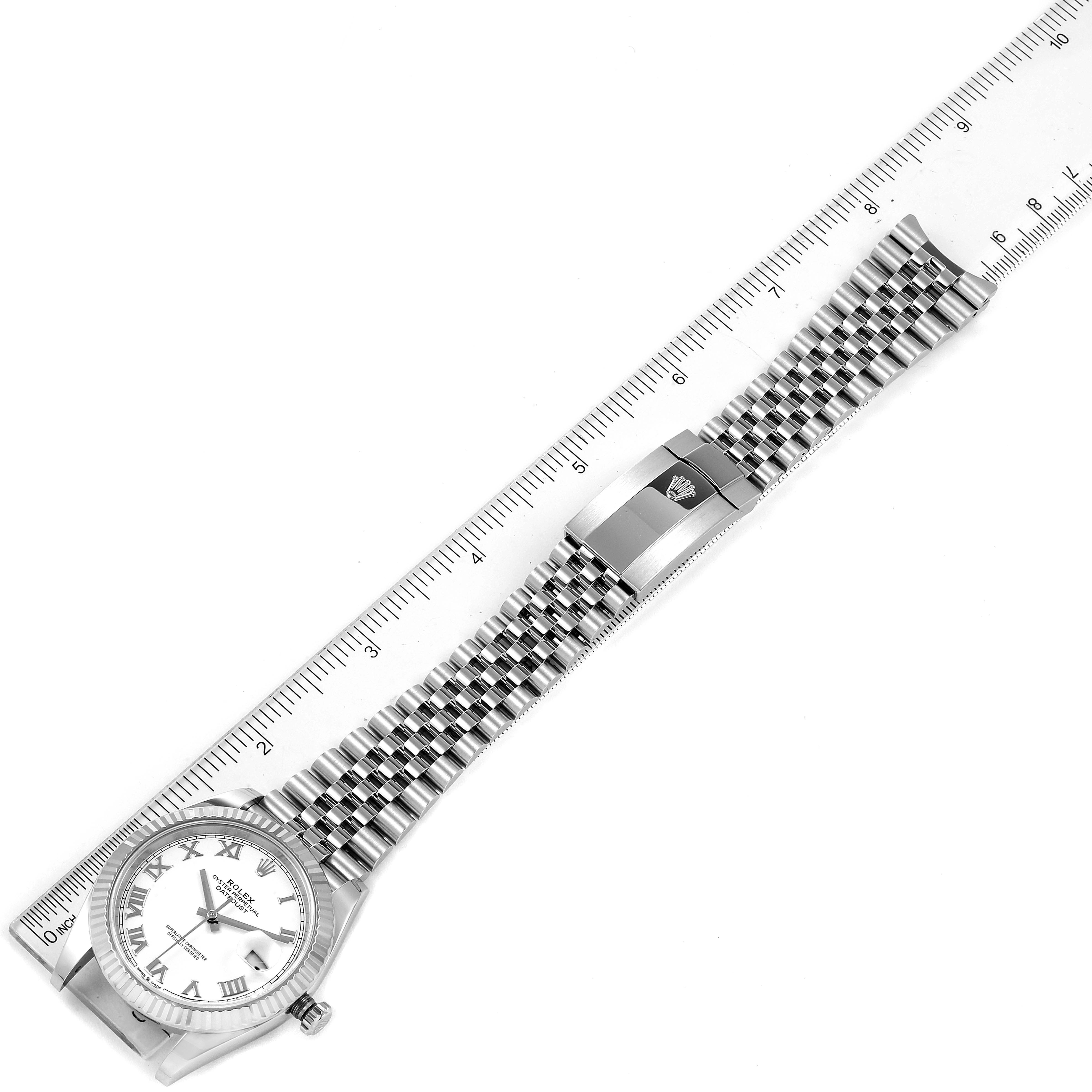 The Rolex Datejust 41 126334 Men
s Stainless Steel White Dial 126334 Men
s Stainless Steel White Dial watch is shown from a top-down angle, with its bracelet extended next to a ruler for scale.