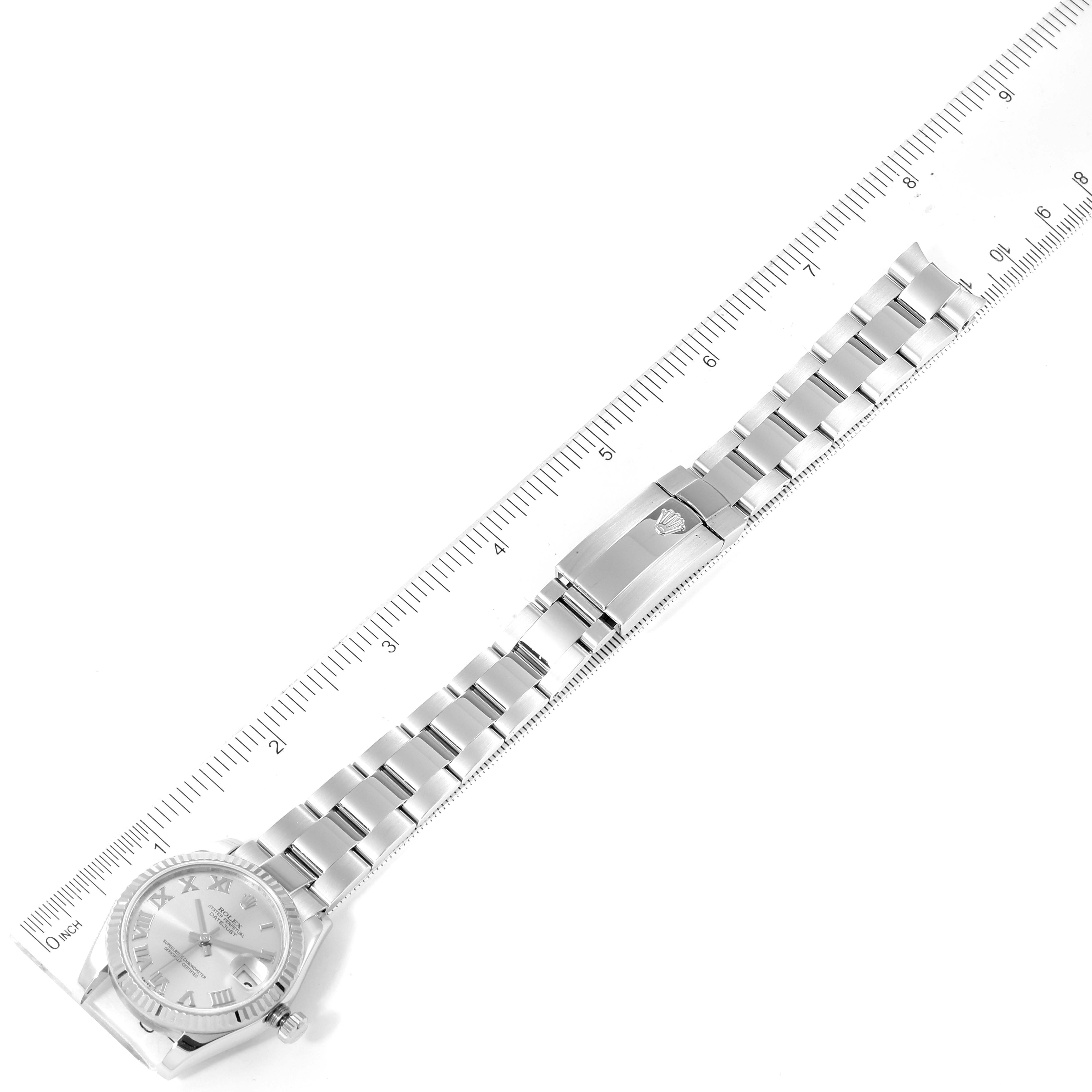 The image shows a bird
s-eye view of a Mid-Size Rolex watch, displaying its face, bracelet, and clasp alongside a ruler for scale.