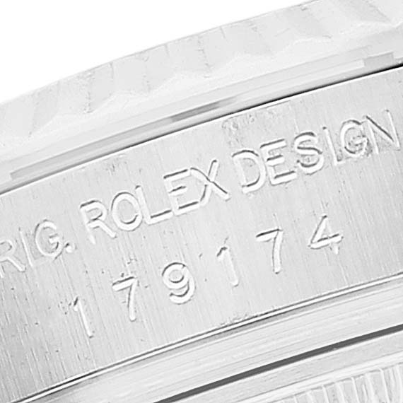The image shows a close-up of the case side of a Rolex Datejust 179174 Women's Stainless Steel Pink Dial 179174 Women's Stainless Steel Pink Dial, highlighting the engraved serial number and "ROLEX DESIGN" text.