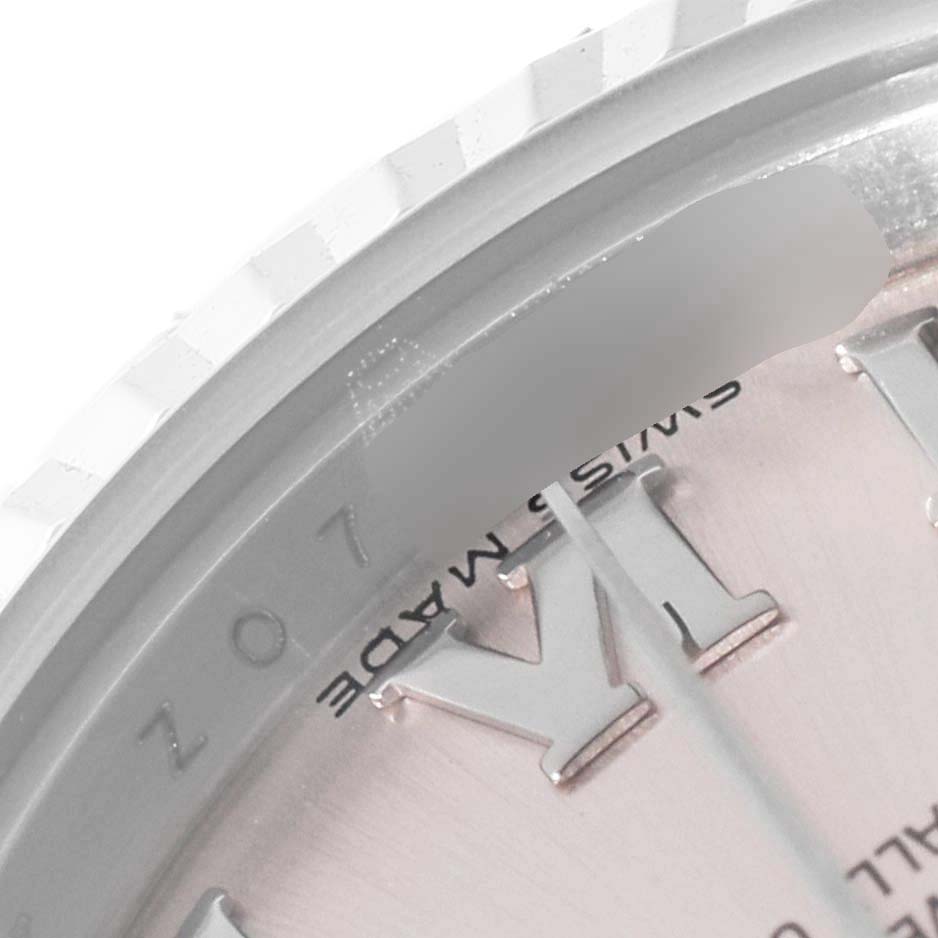 This close-up image shows a portion of the bezel and the dial with Roman numerals of a Rolex Datejust 179174 Women's Stainless Steel Pink Dial 179174 Women's Stainless Steel Pink Dial watch.