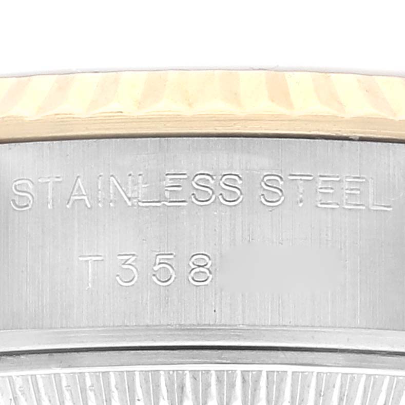 This close-up image shows the side engraving and bezel detail of a Rolex Datejust 69173 Women's Steel and Gold (two tone) Champagne Dial 69173 Women's Steel and Gold (two tone) Champagne Dial watch, focusing on the "Stainless Steel" text and part of the serial number.