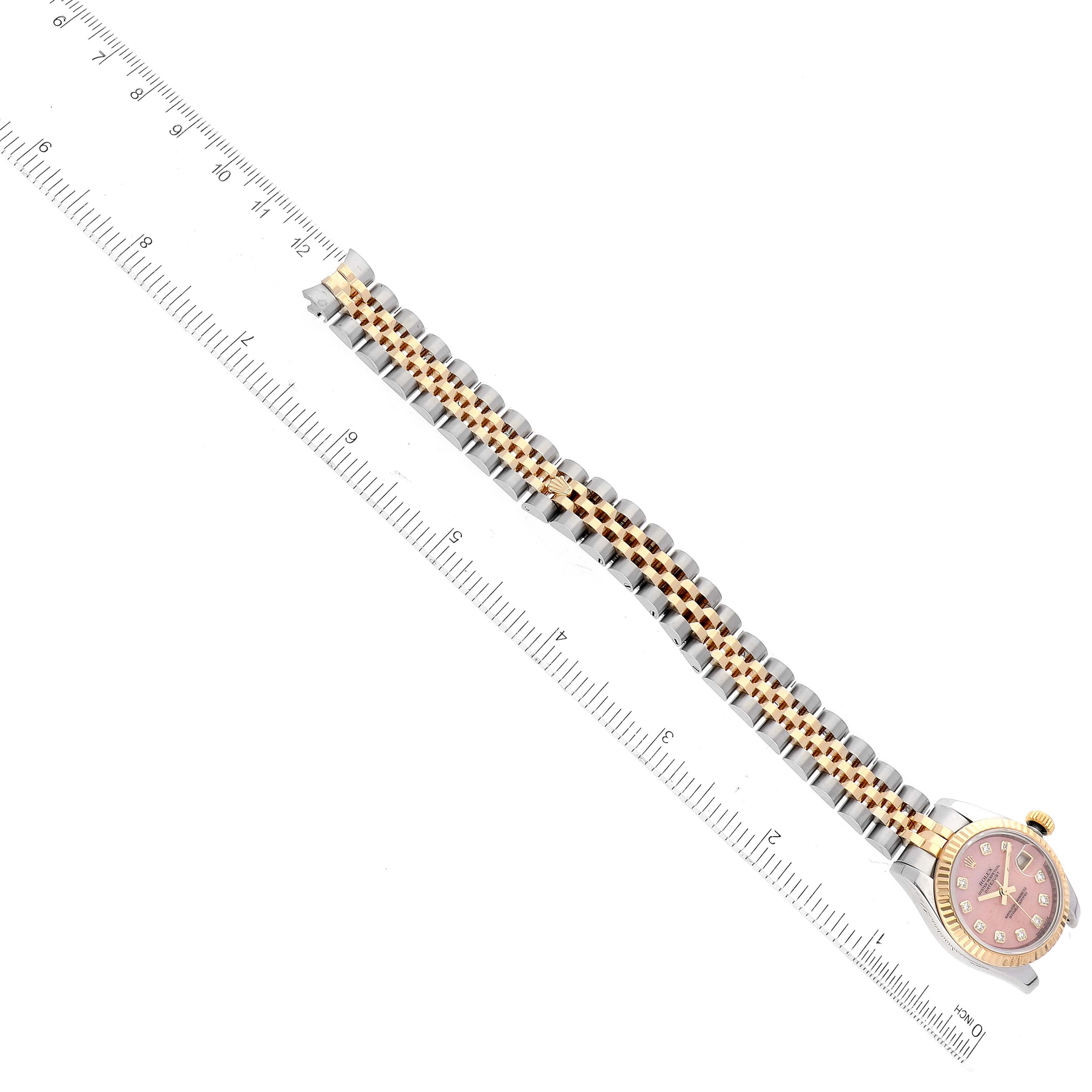 The image shows a Rolex Datejust 179173 Women's Steel and Gold (two tone) Pink Dial 179173 Women's Steel and Gold (two tone) Pink Dial watch laying flat with its full bracelet extended alongside a ruler for scale.