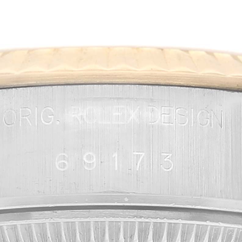 The image shows a close-up of the side case of a Rolex Datejust 69173 Women's Steel and Gold (two tone) Champagne Dial 69173 Women's Steel and Gold (two tone) Champagne Dial, highlighting the model number and engraving "ORIG. ROLEX DESIGN 69173."