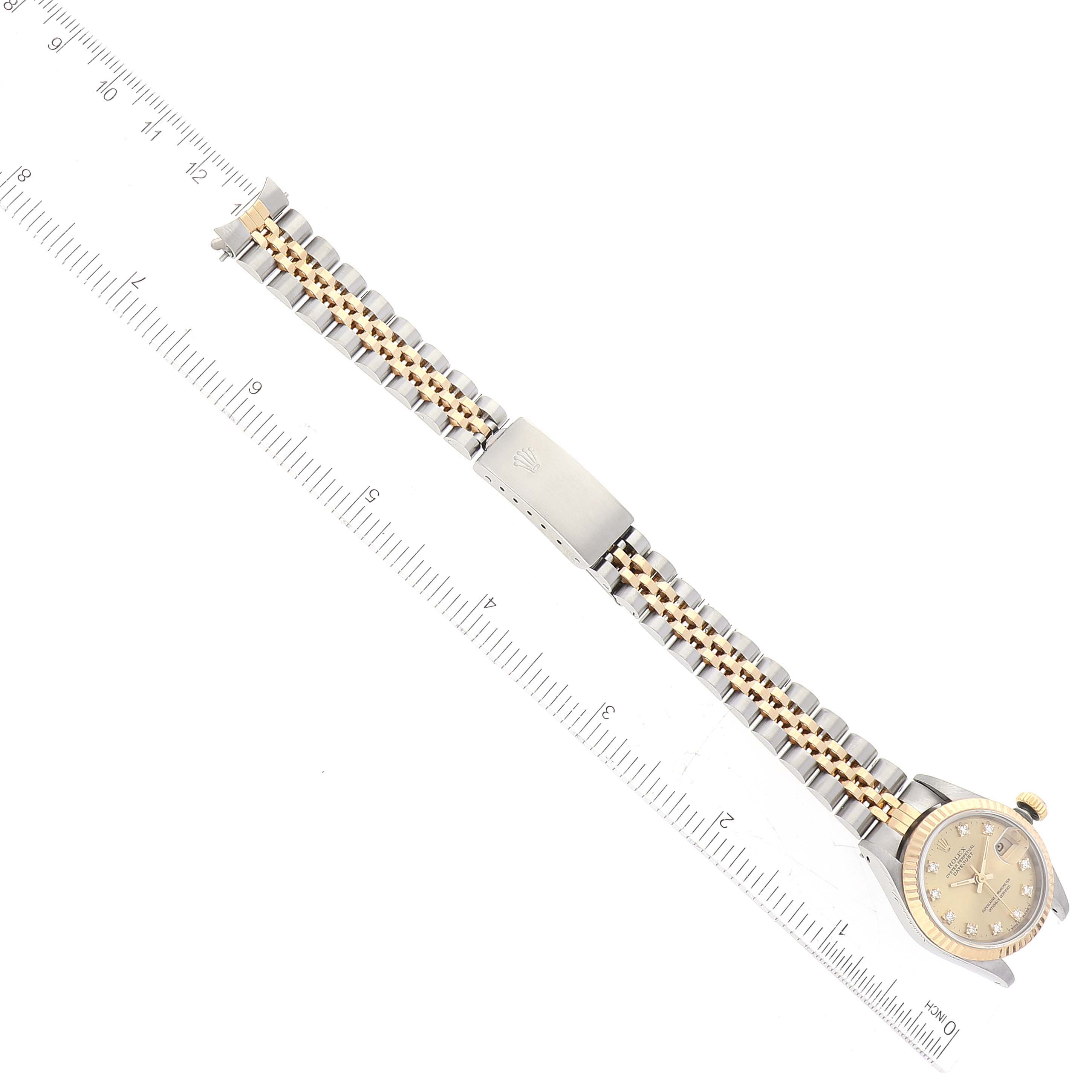 The image shows a Rolex Datejust 69173 Women's Steel and Gold (two tone) Champagne Dial 69173 Women's Steel and Gold (two tone) Champagne Dial watch laid flat next to a ruler, displaying the face, band, and clasp.