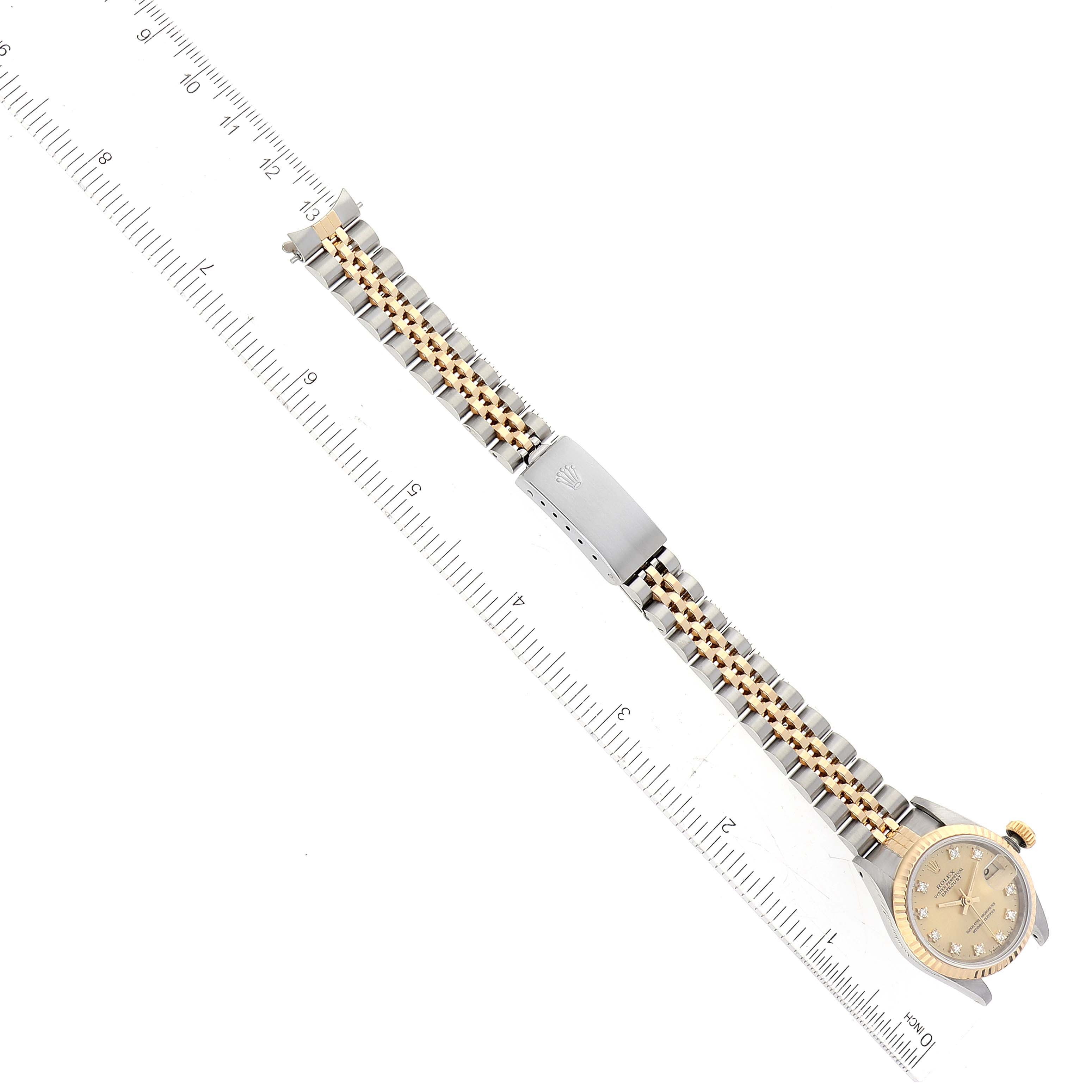 This image shows the Rolex Datejust 69173 Women's Steel and Gold (two tone) Champagne Dial 69173 Women's Steel and Gold (two tone) Champagne Dial watch placed horizontally, a ruler beside it measuring the length, and the detail of the bracelet.