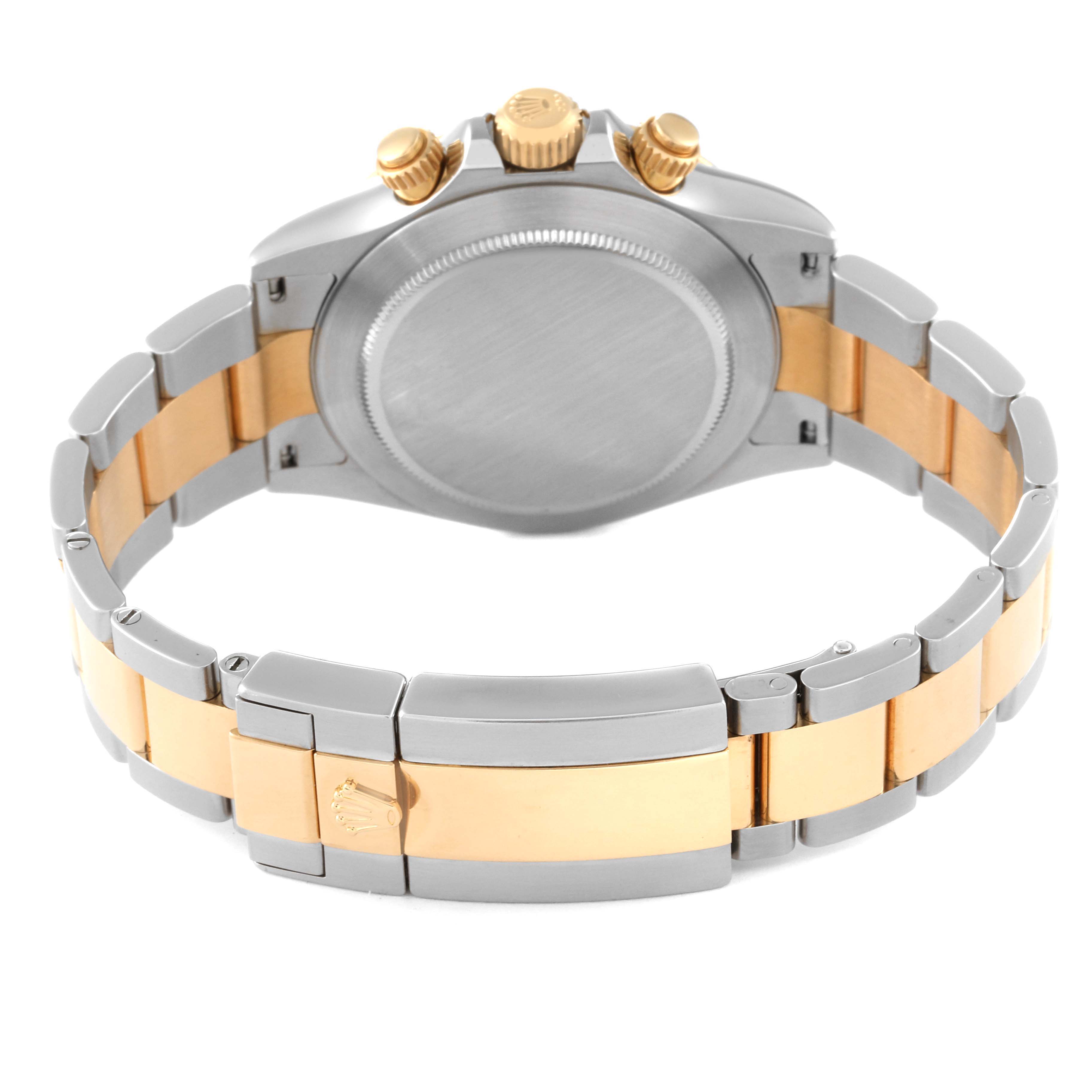 The image shows the back view of a Rolex Daytona 116523 Men's Steel and Gold (two tone) Blue Dial 116523 Men's Steel and Gold (two tone) Blue Dial watch, highlighting its case, crown, pushers, and two-tone bracelet.